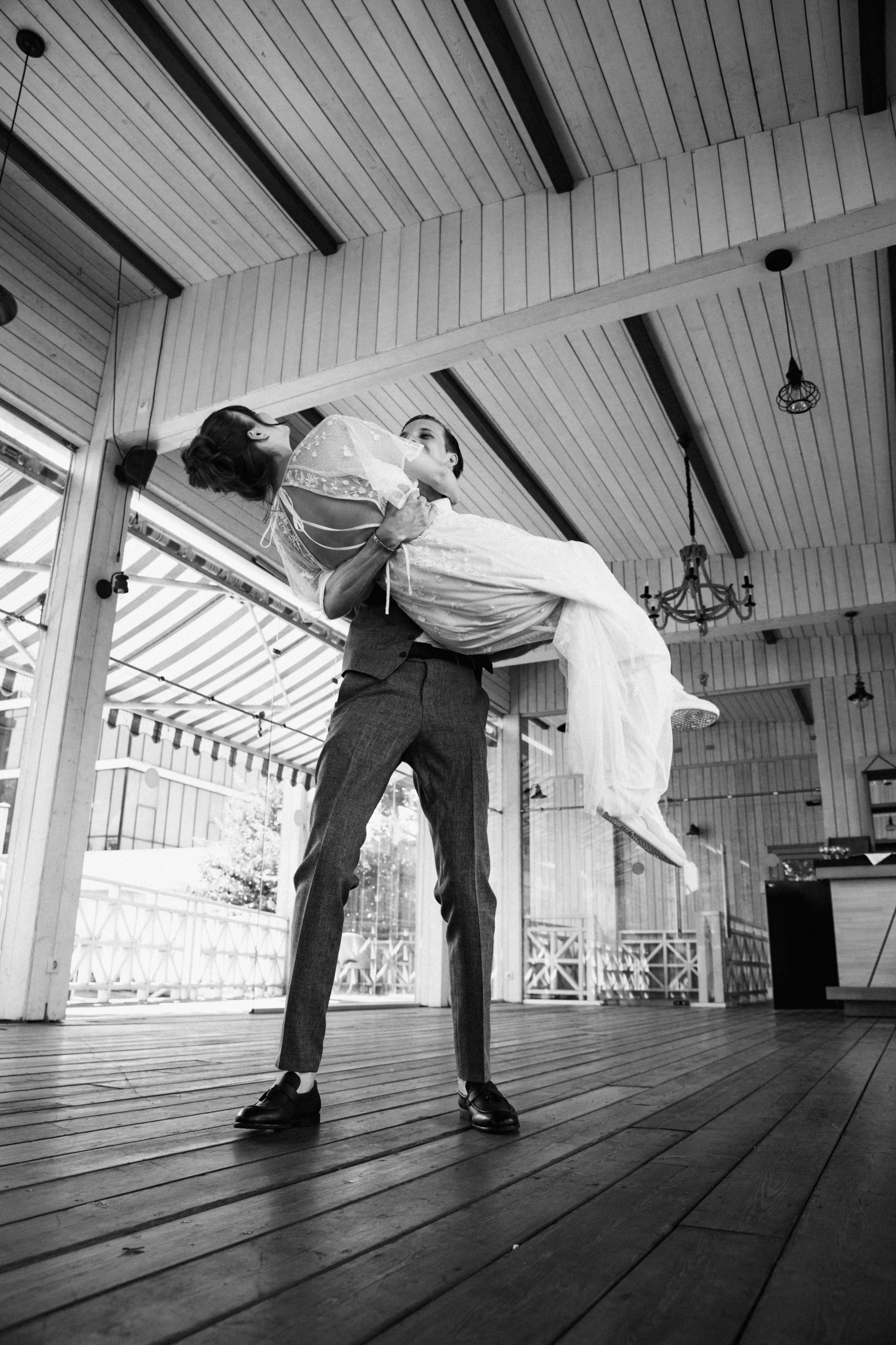 Крик счастья—улыбки гостей, пара выходит из здания в белых венках и boutonniers.