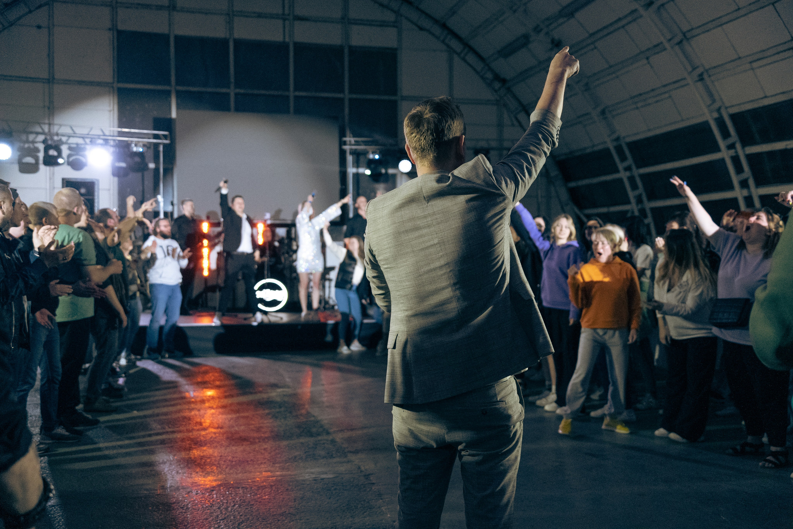 Молодые люди смотрят на сцену и реагируют на мероприятие в клубной атмосфере