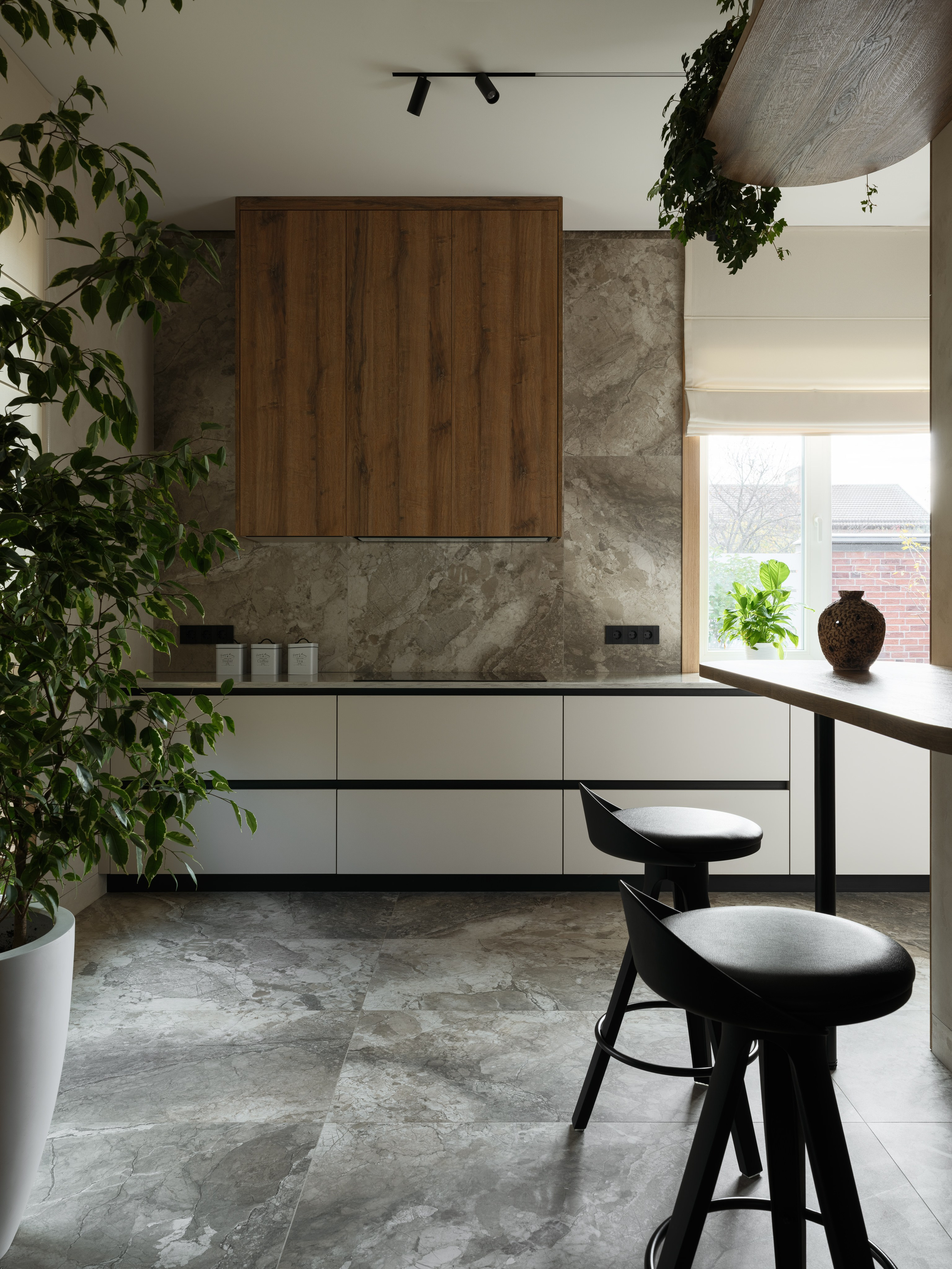 Кухня с минималистичными белыми фасадами и акцентной отделкой деревом и камнем. Современный интерьер, созданный Наталией Шелепниковой, сфотографированный Сергеем Денисенко и застилизованный Алёной Бершацкой, наполнен светом и уютом.