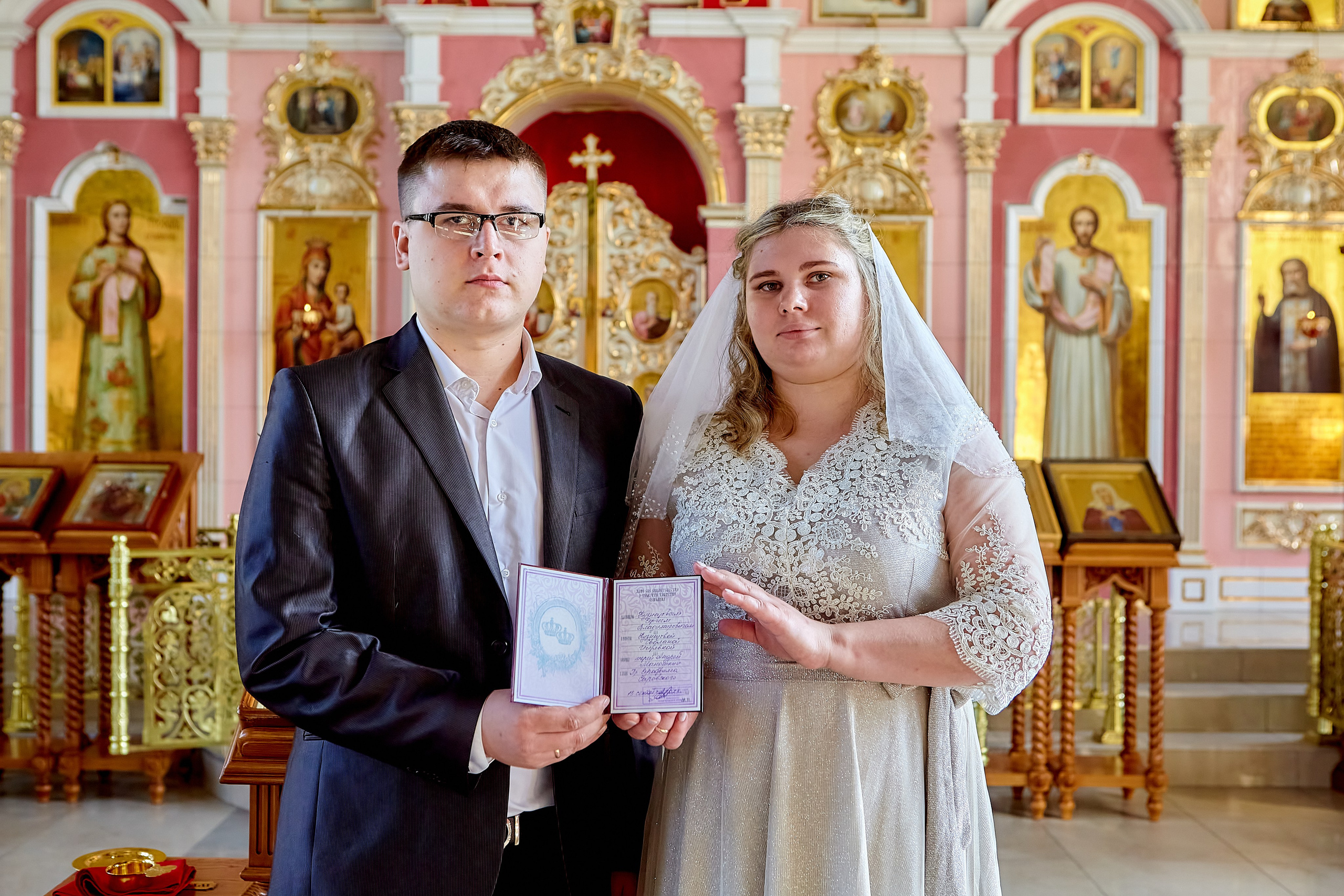 Жених и Невеста со свидетельством о венчании в руках 