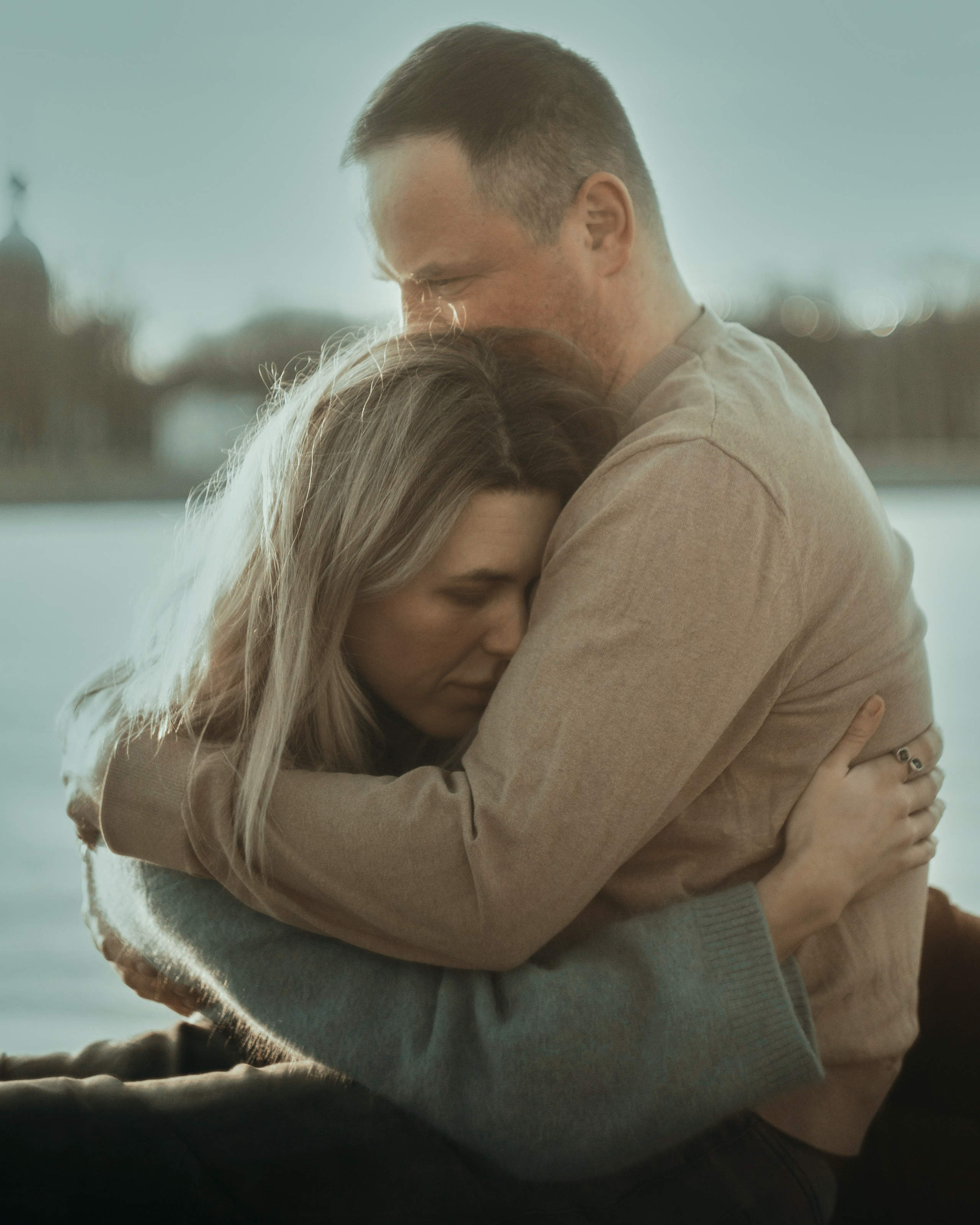 Нежная фотосессия влюбленных у воды, объятия пары на закате, съемка для пары, которой важны смысл и близость в Санкт-Петербурге