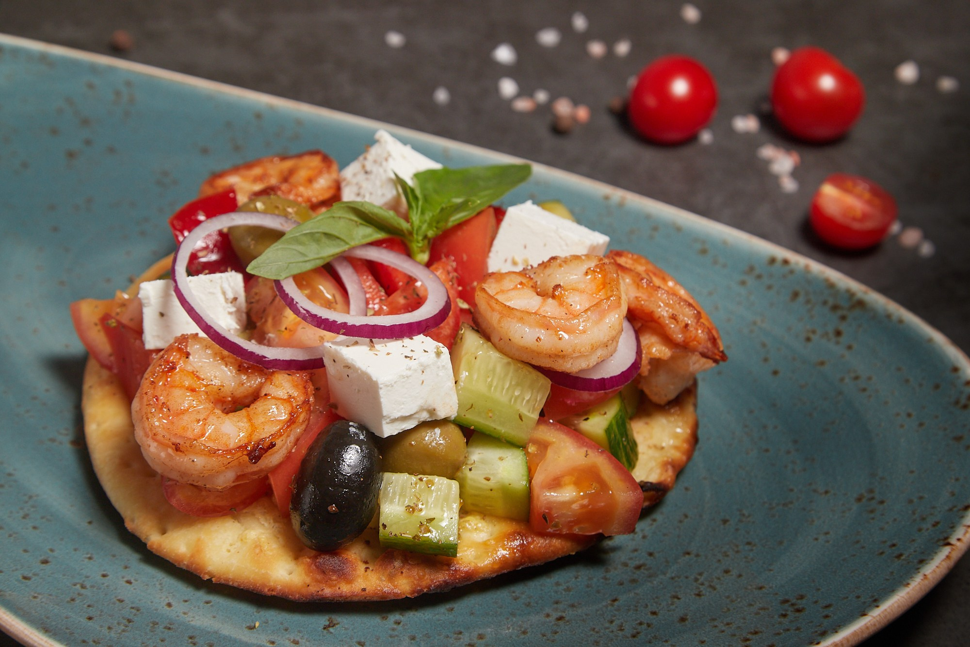 Фуд-фотография запечённых овощей с соусом и зеленью.