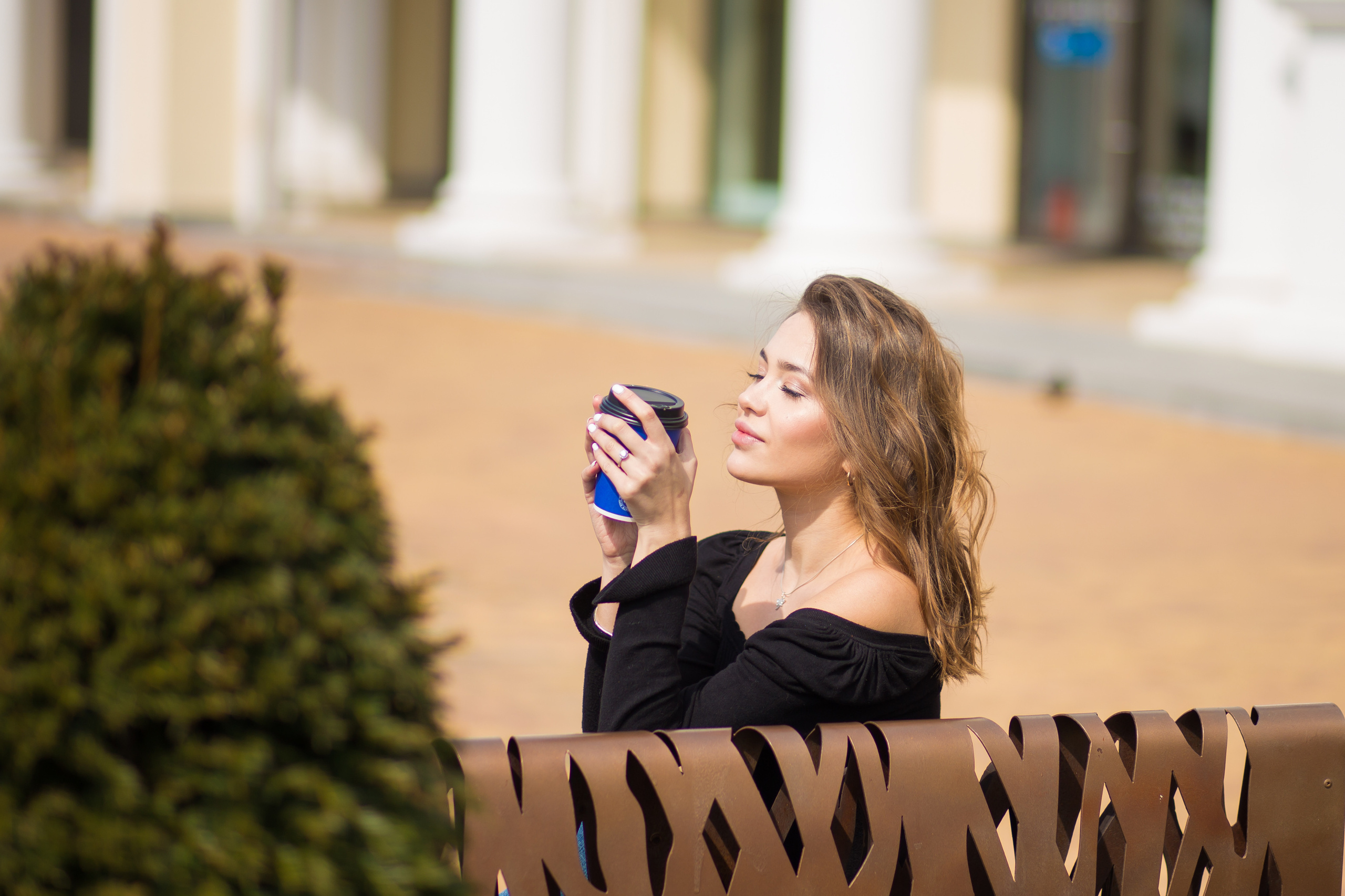 девушка сидит счастливая с кружкой кофе