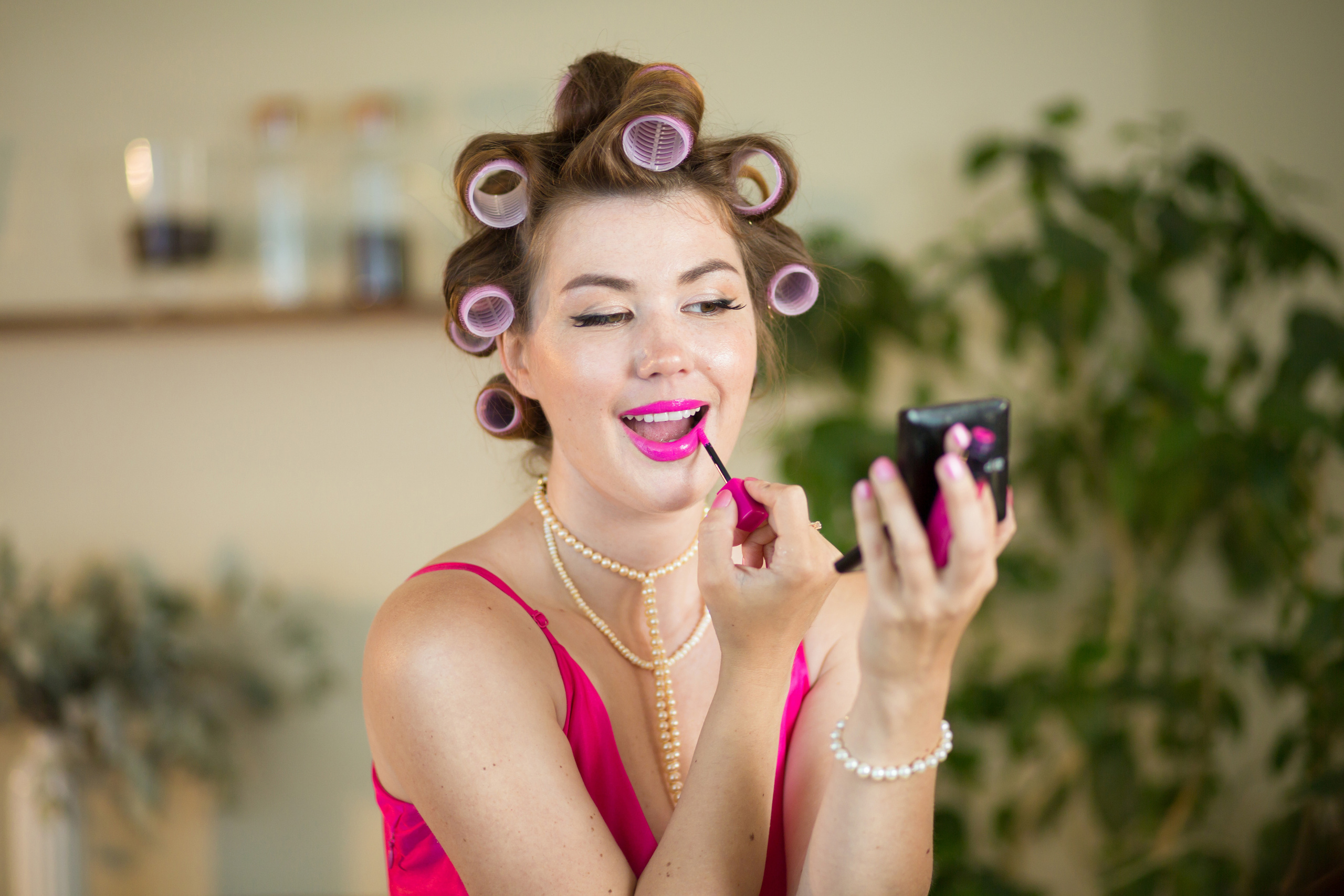 портрет девушки с бигудями, которая красит губы