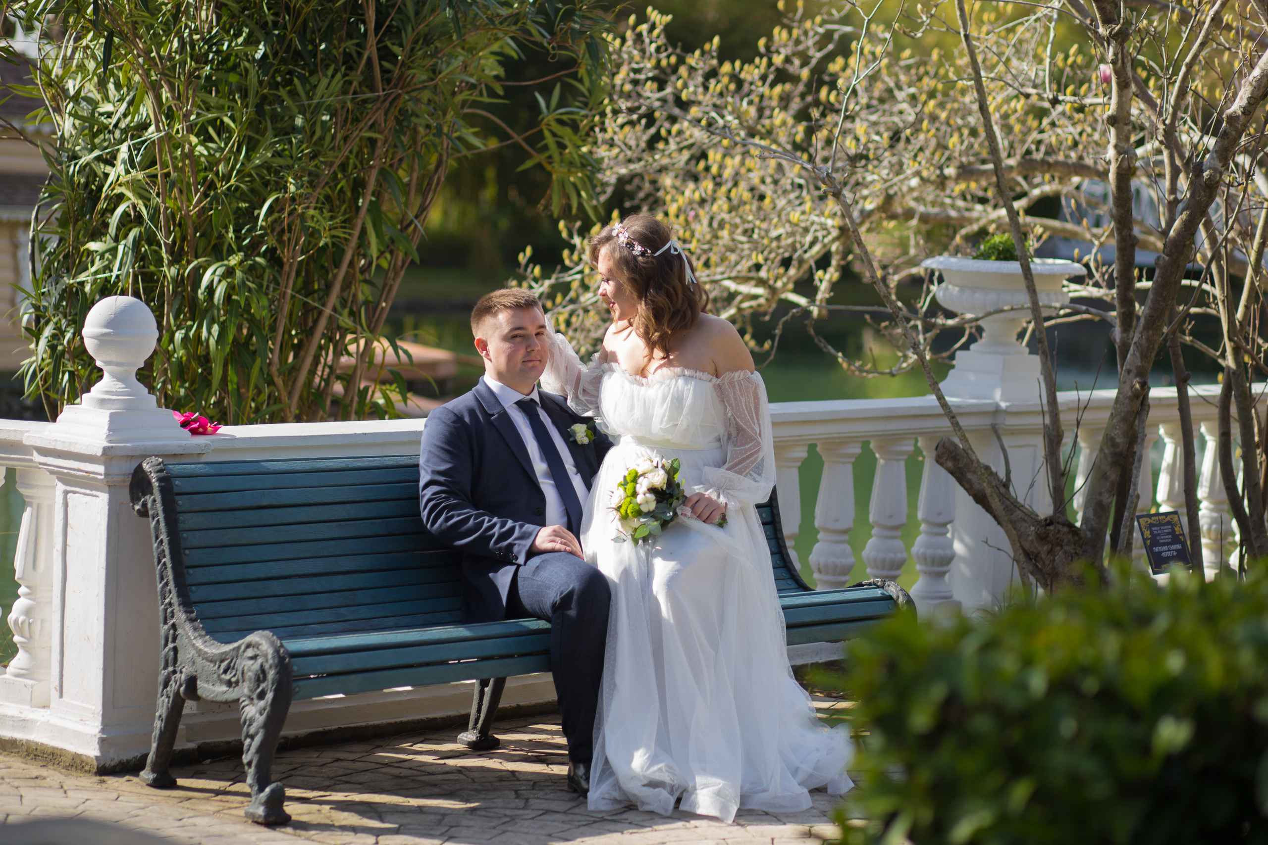 невеста сидит на коленях у жениха в парке