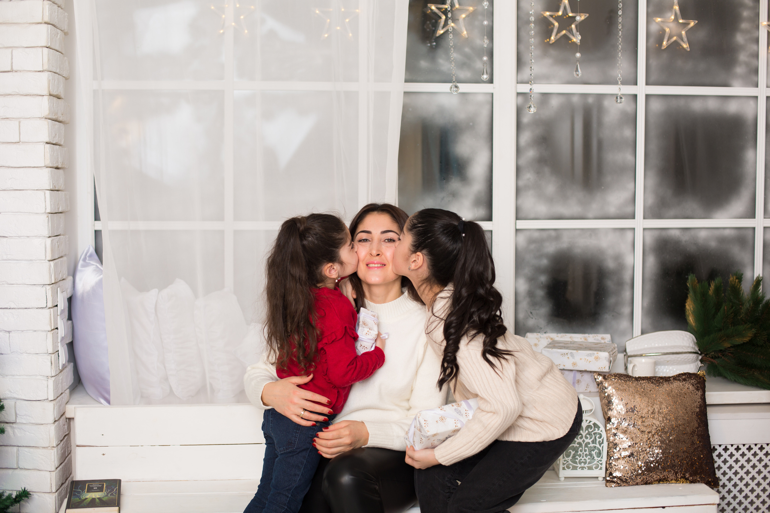 дочери целуют маму