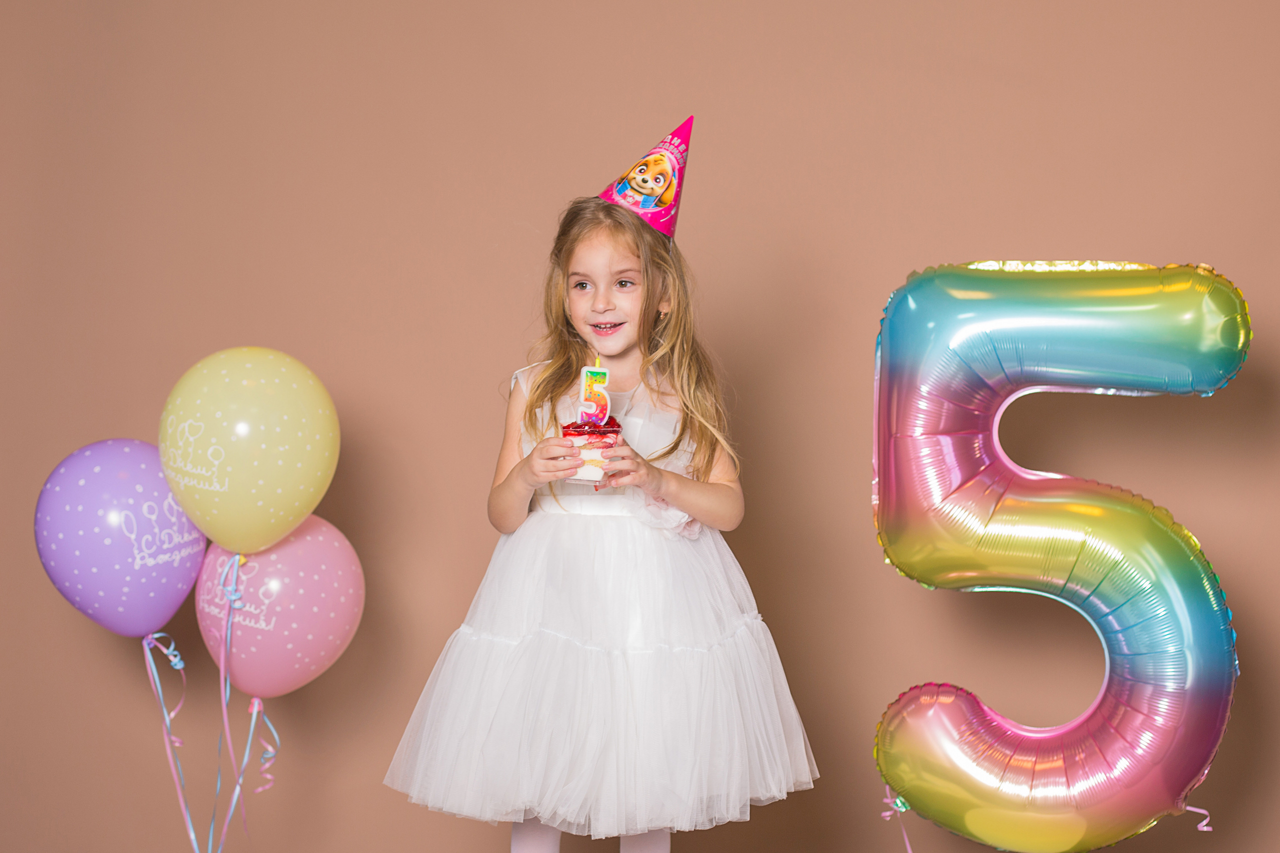 девочка в  праздничном колпаке и шарами