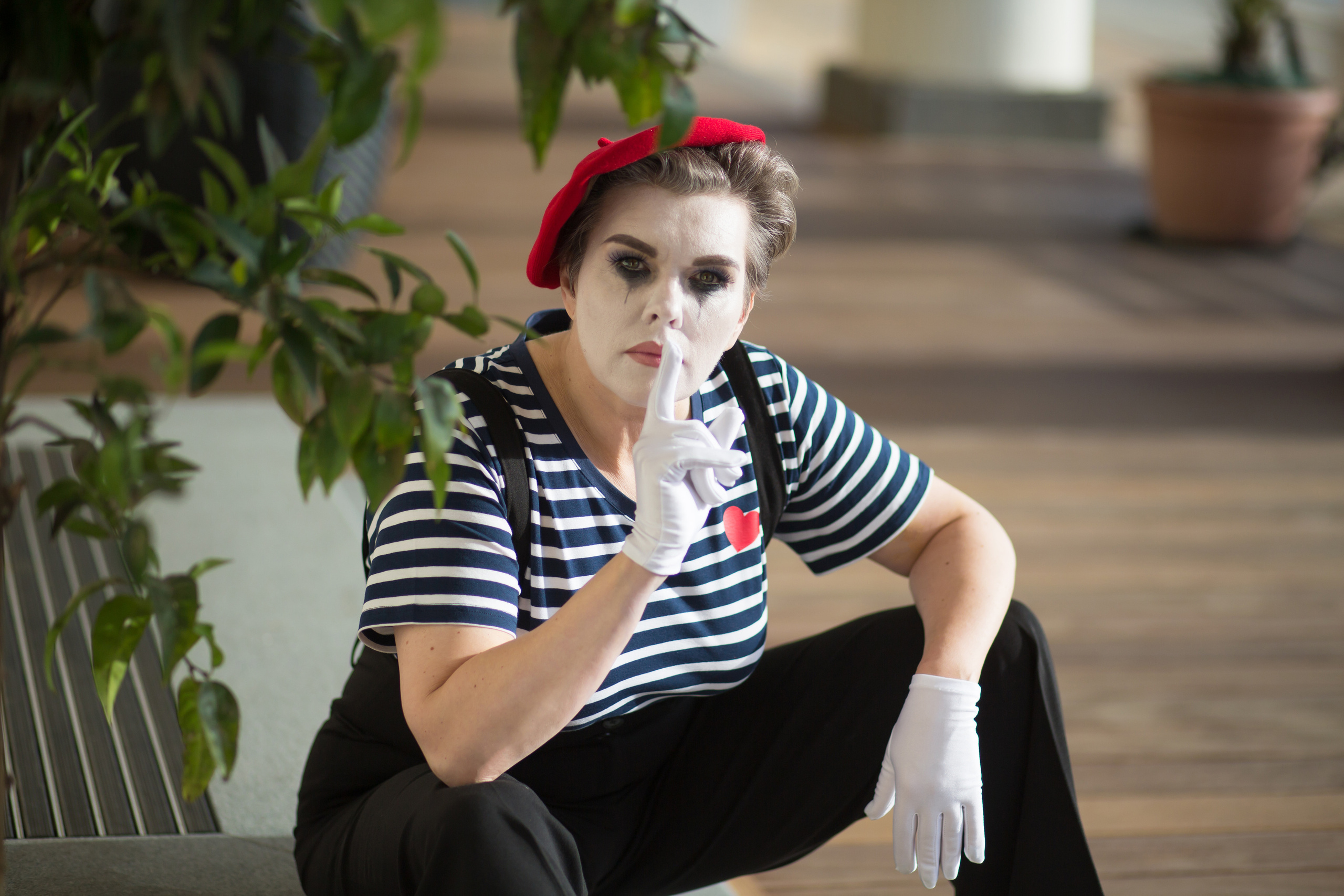 портрет накрашенного мима, который сидит в перчатках