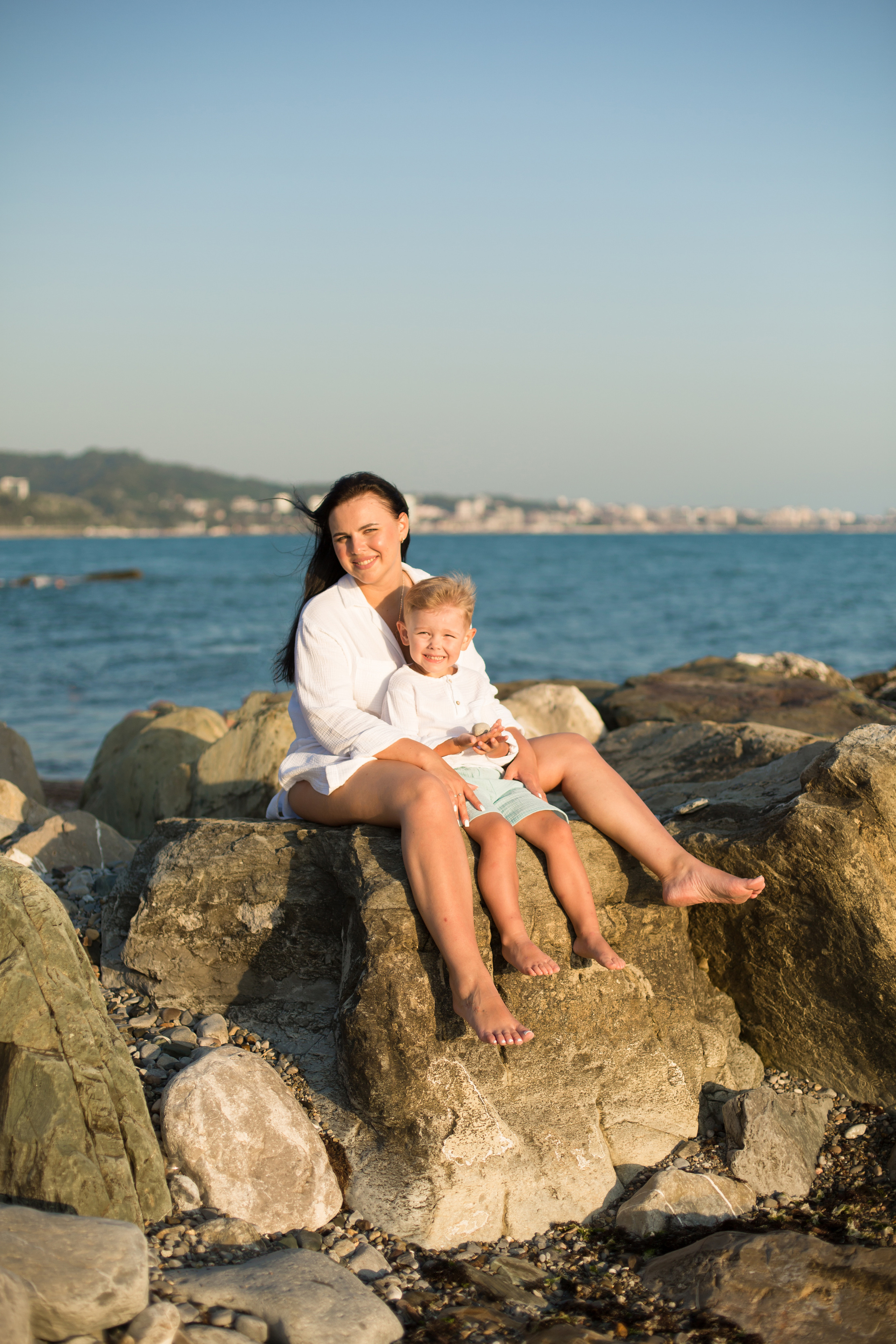 мама и сын сидят на камнях