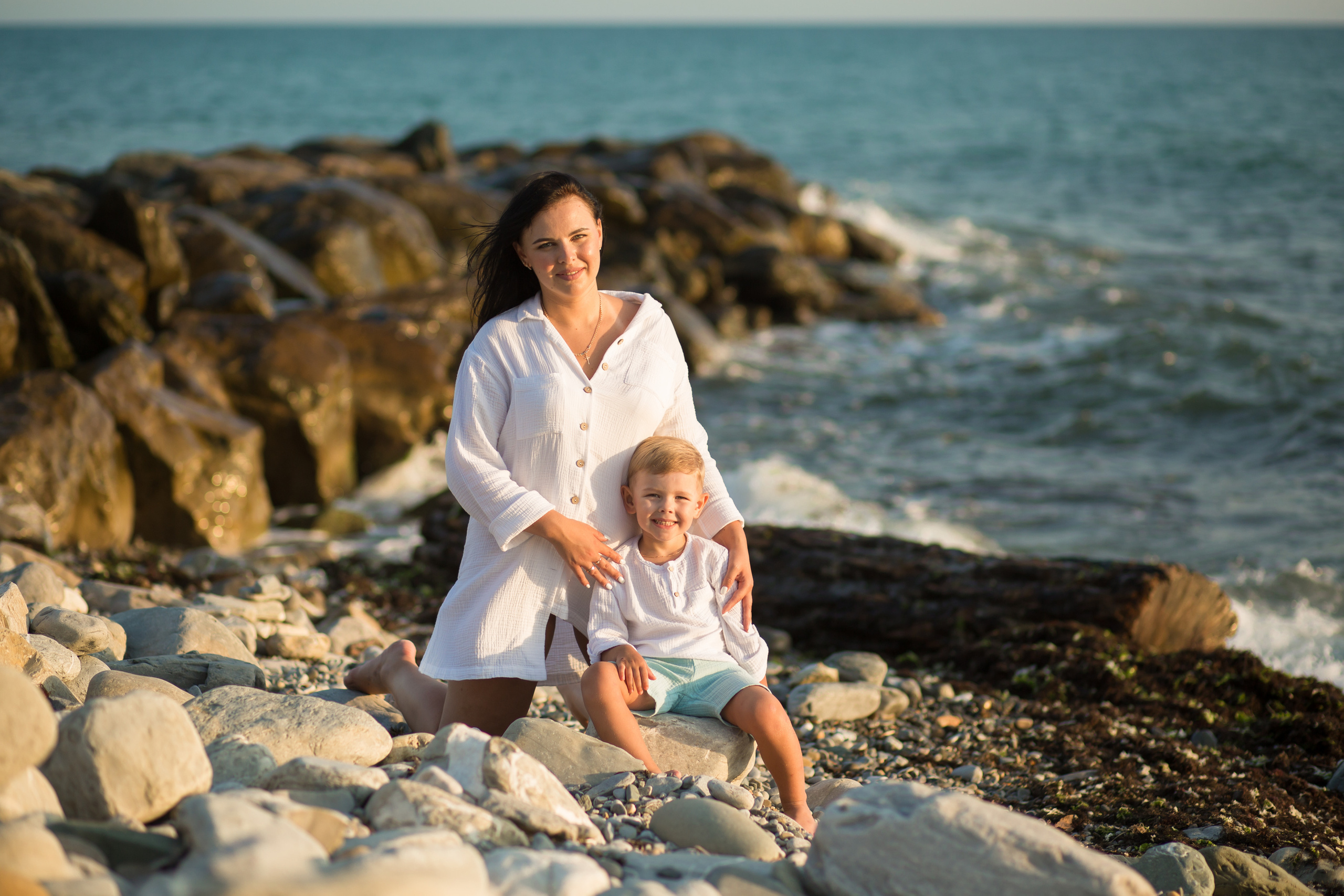 мальчик с мамой у моря на каменистом пляже