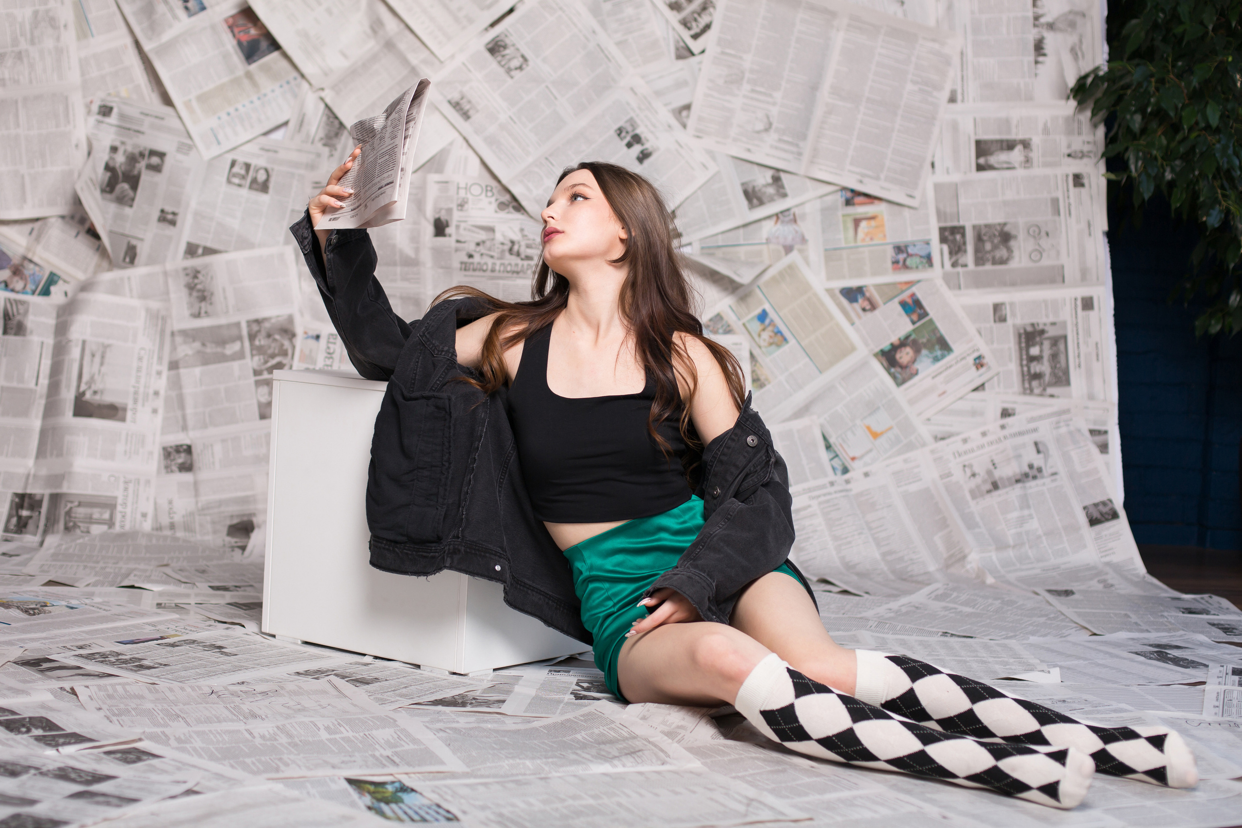 девушка читает газету на полу на фоне газет