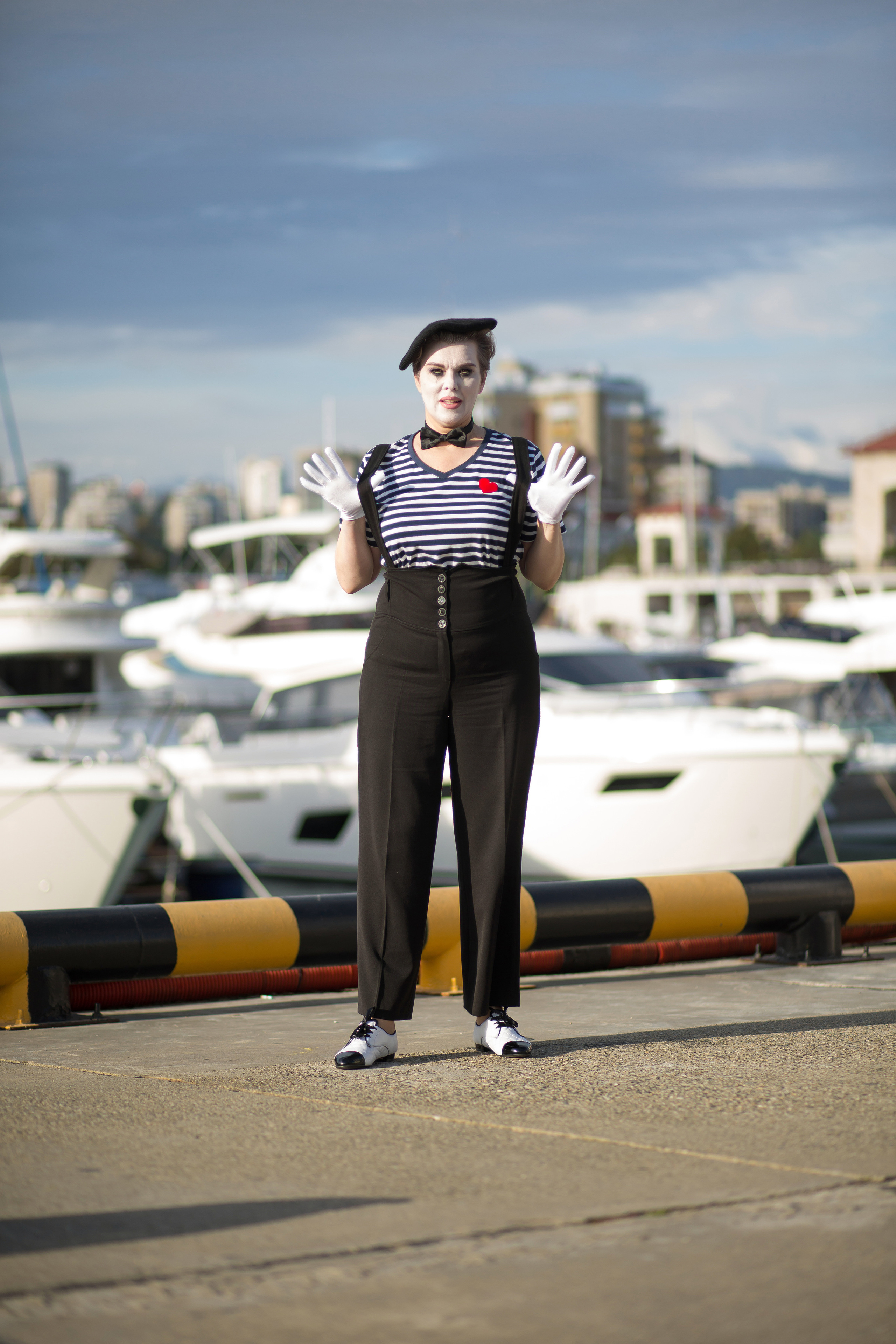 мим стоит на фоне яхт