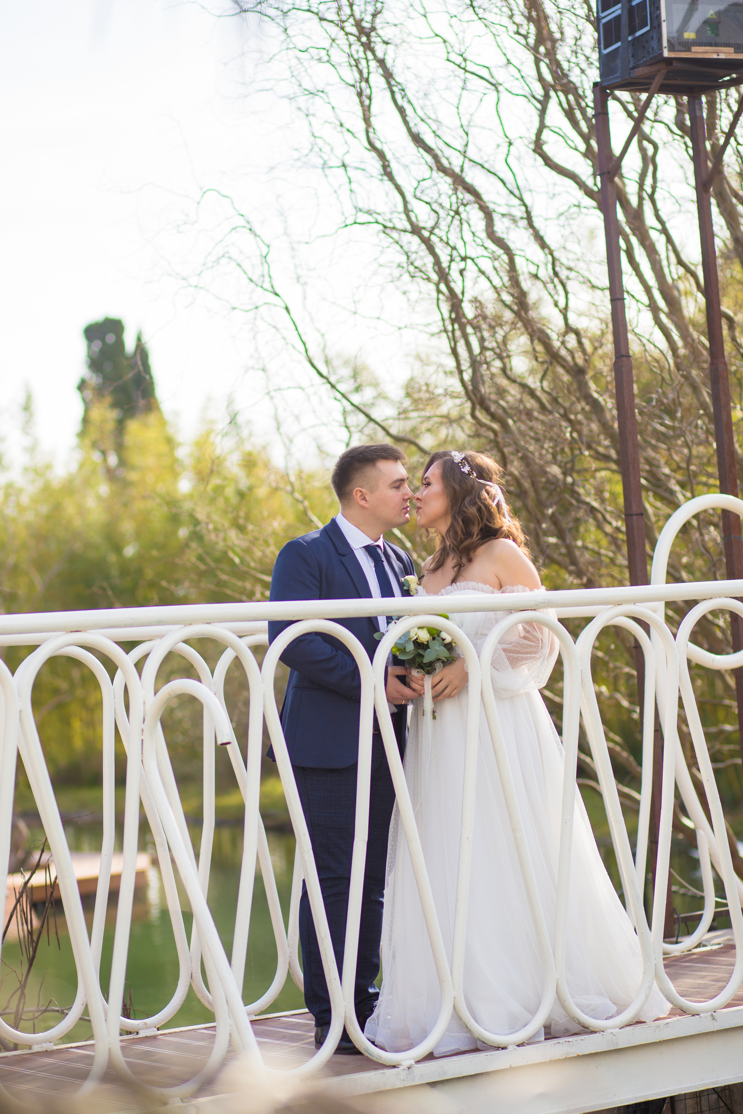жених и невеста обнимаются на мостике