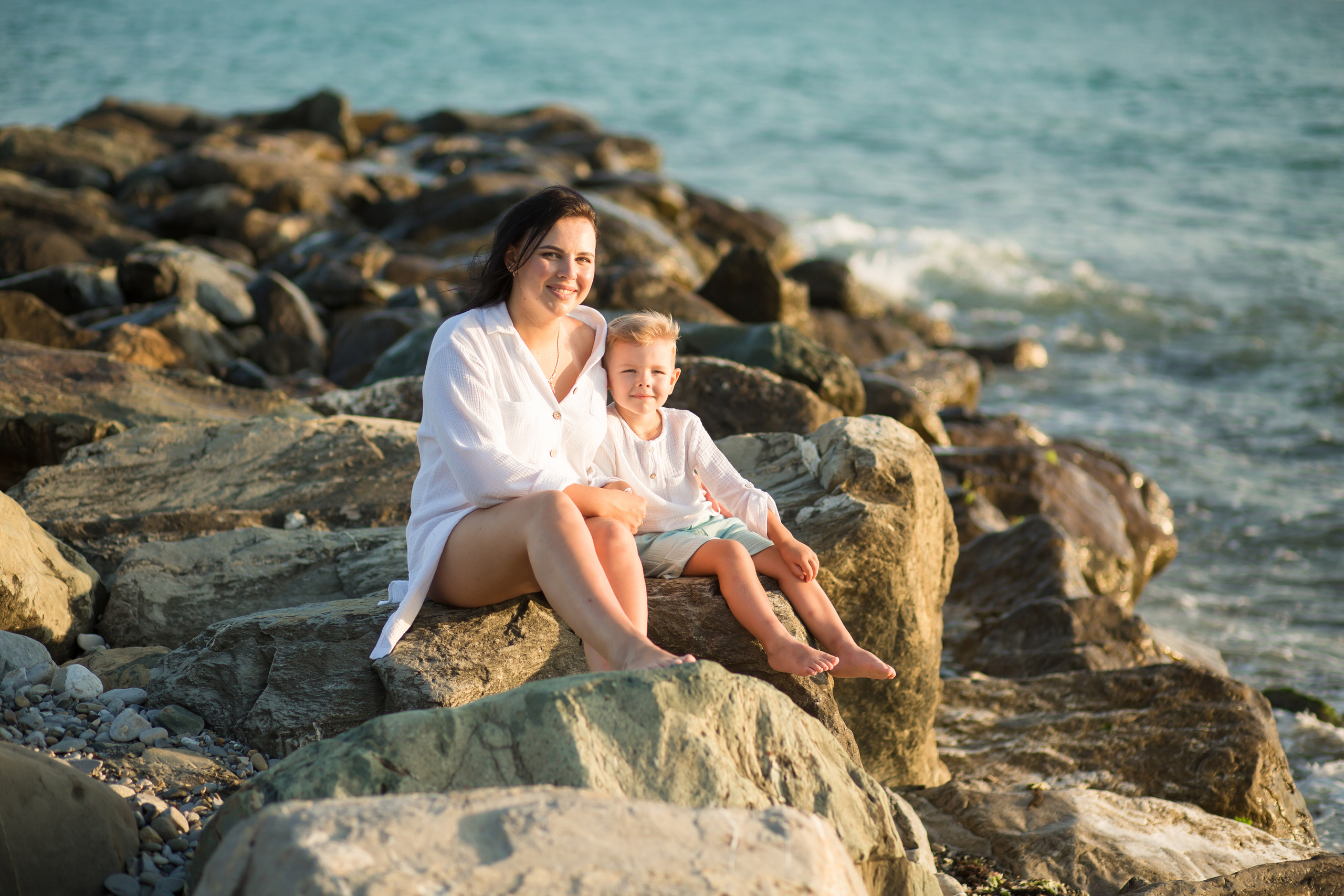 мамы и сын на каменистом пляже