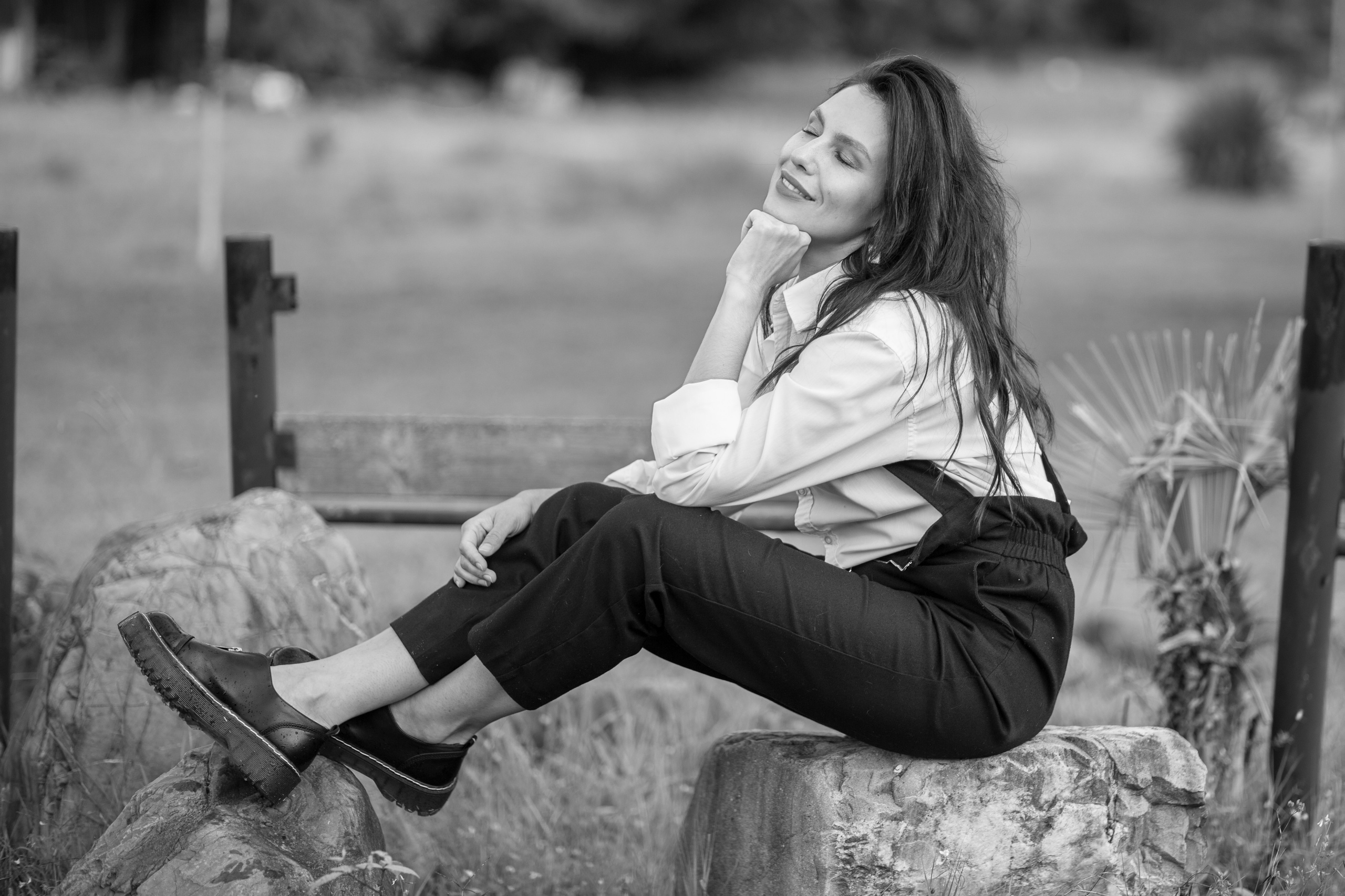 девушка сидит радостная на камнях