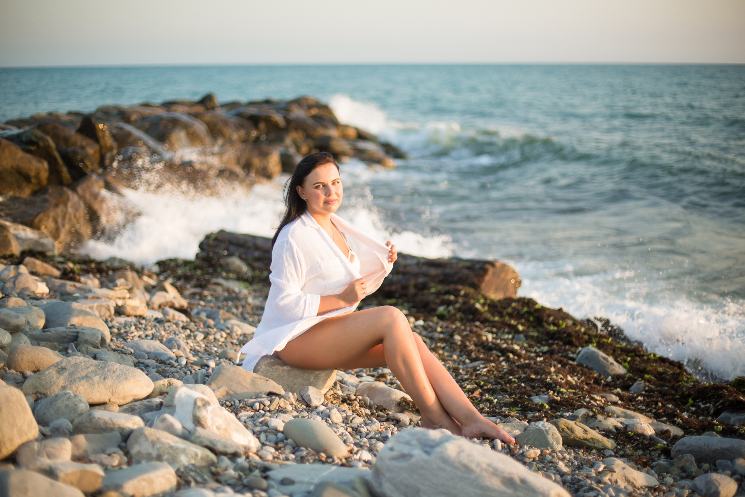 девушка у моря сидит в рубашке