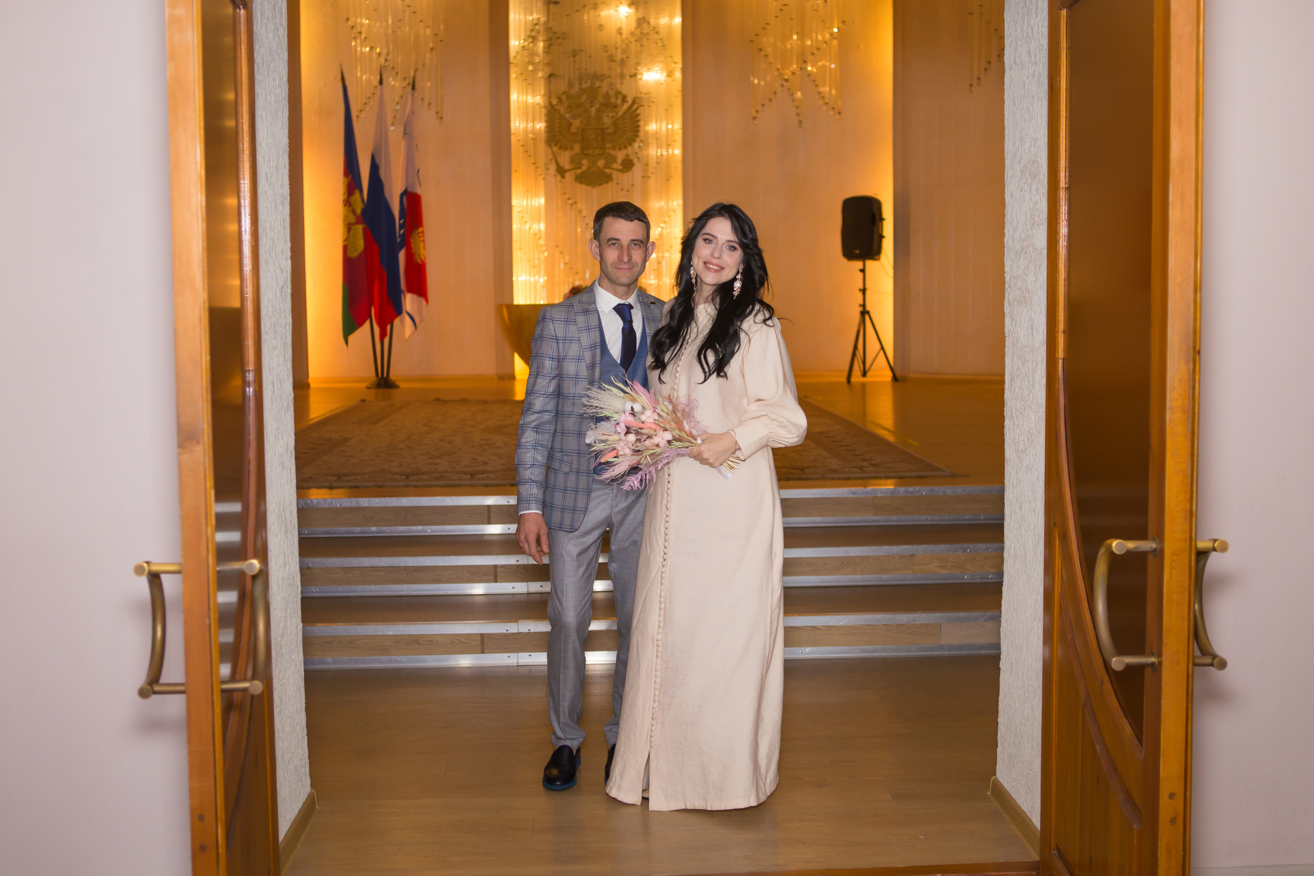 Жених и невеста стоят у входа в ЗАГС