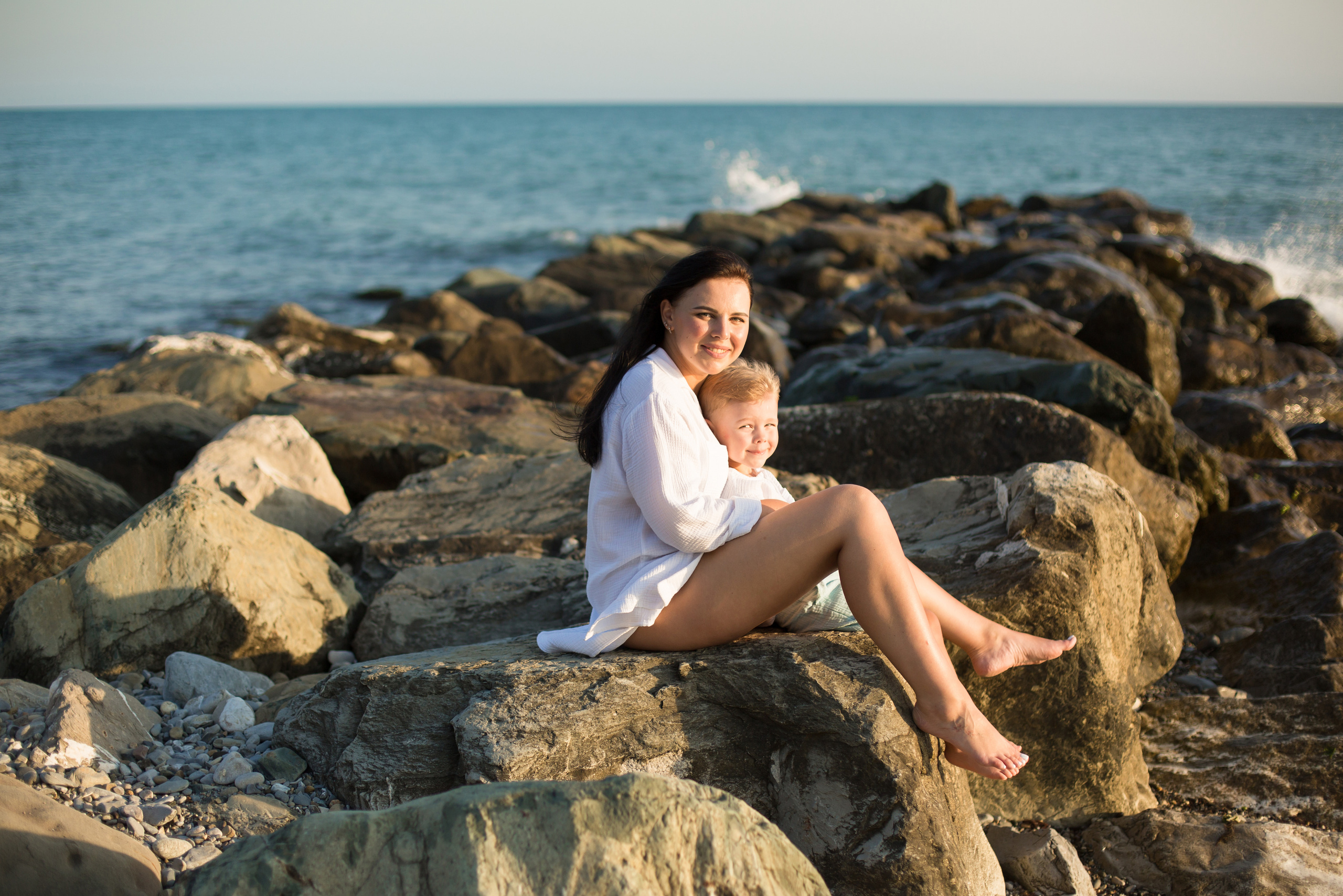 сын с мамой сидят у моря