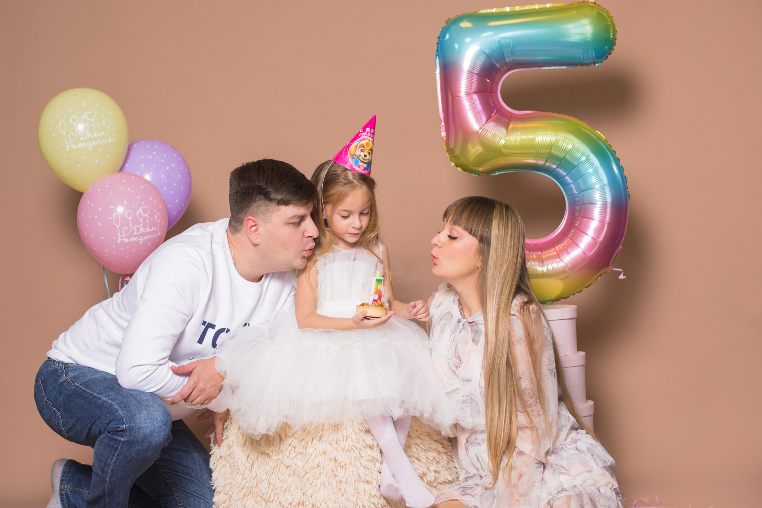 дочь с мамой и папой задувает свечу