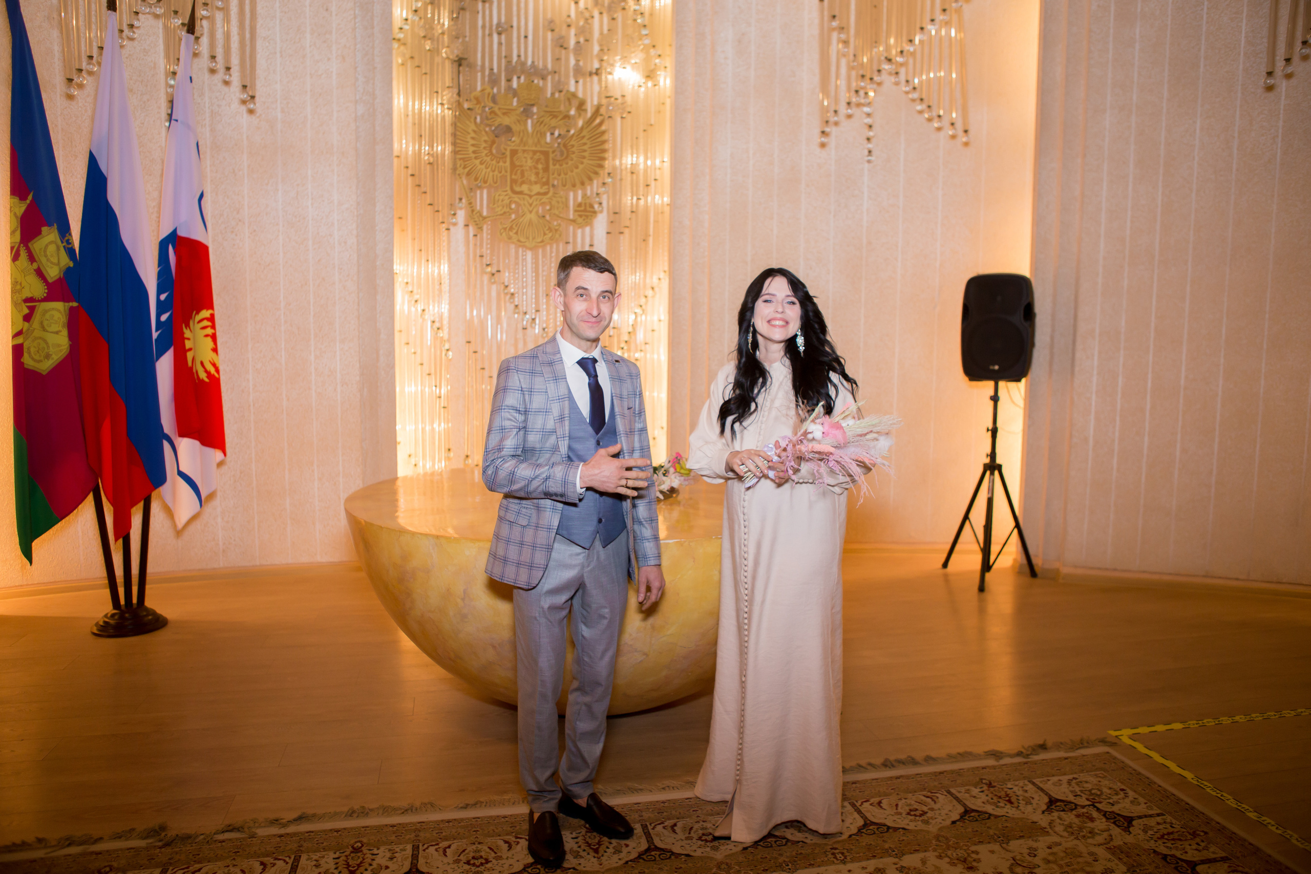 Жених и невеста стоят счастливые в зале регистрации брака