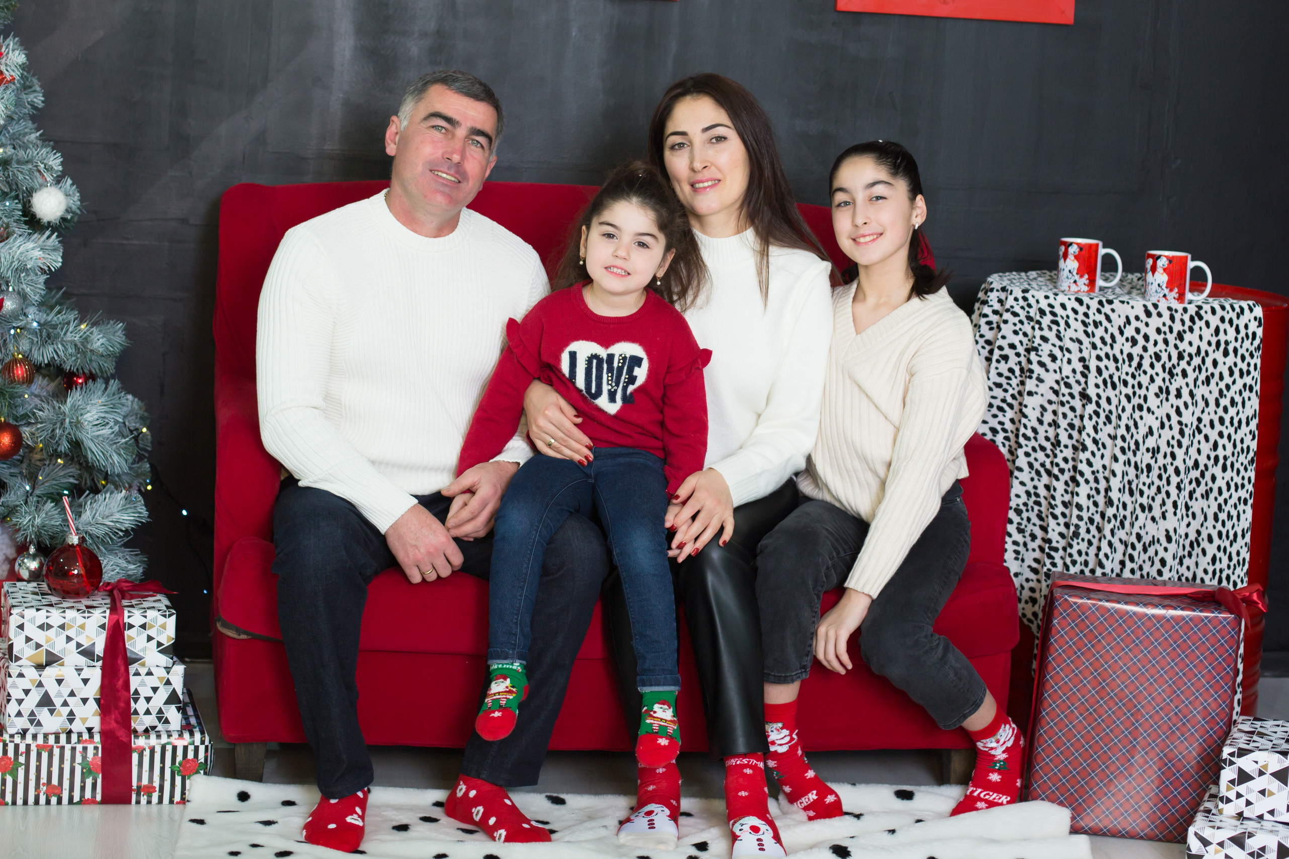 семья мама папа 2 дочери сидят на диване