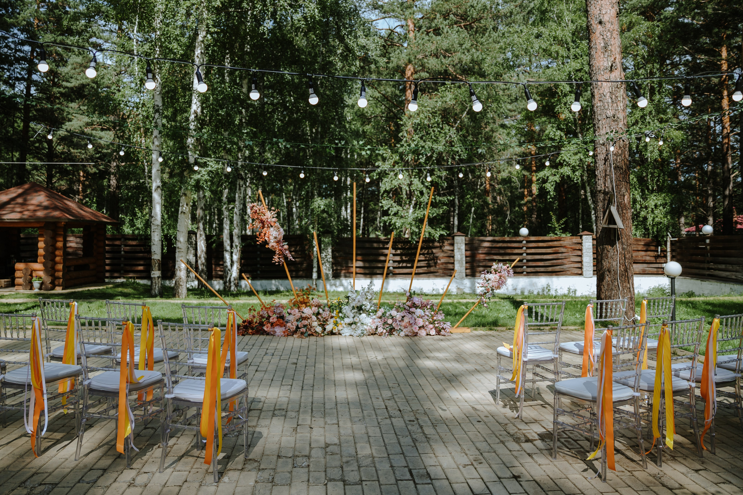 Свадебная арка на улице летом, оранжевые ленты.