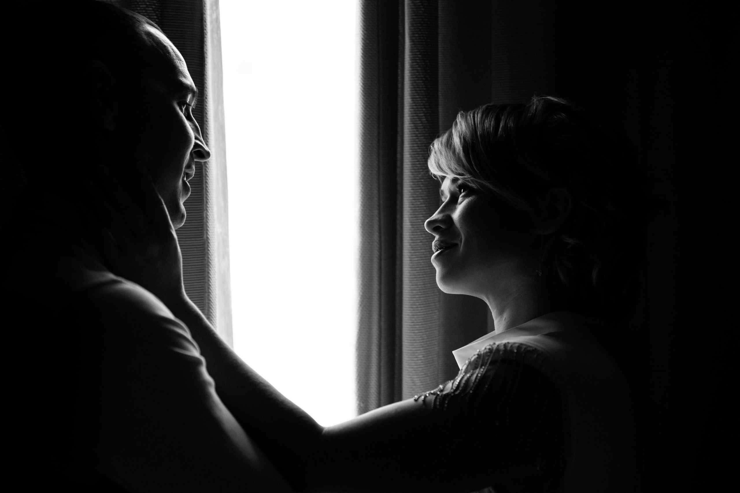 черно-белое фото жениха и невесты у окна