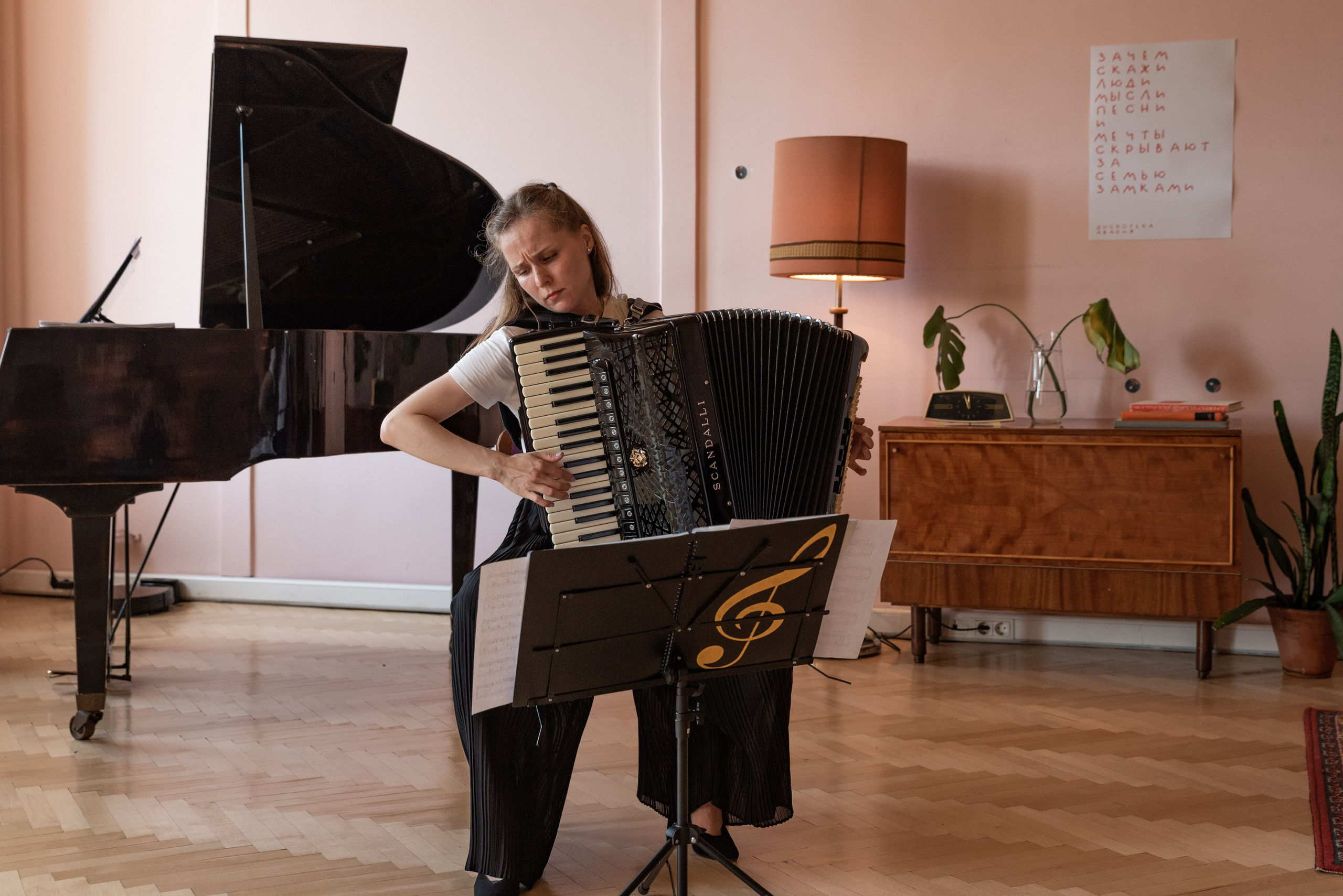 Девушка играет на аккордеоне.
