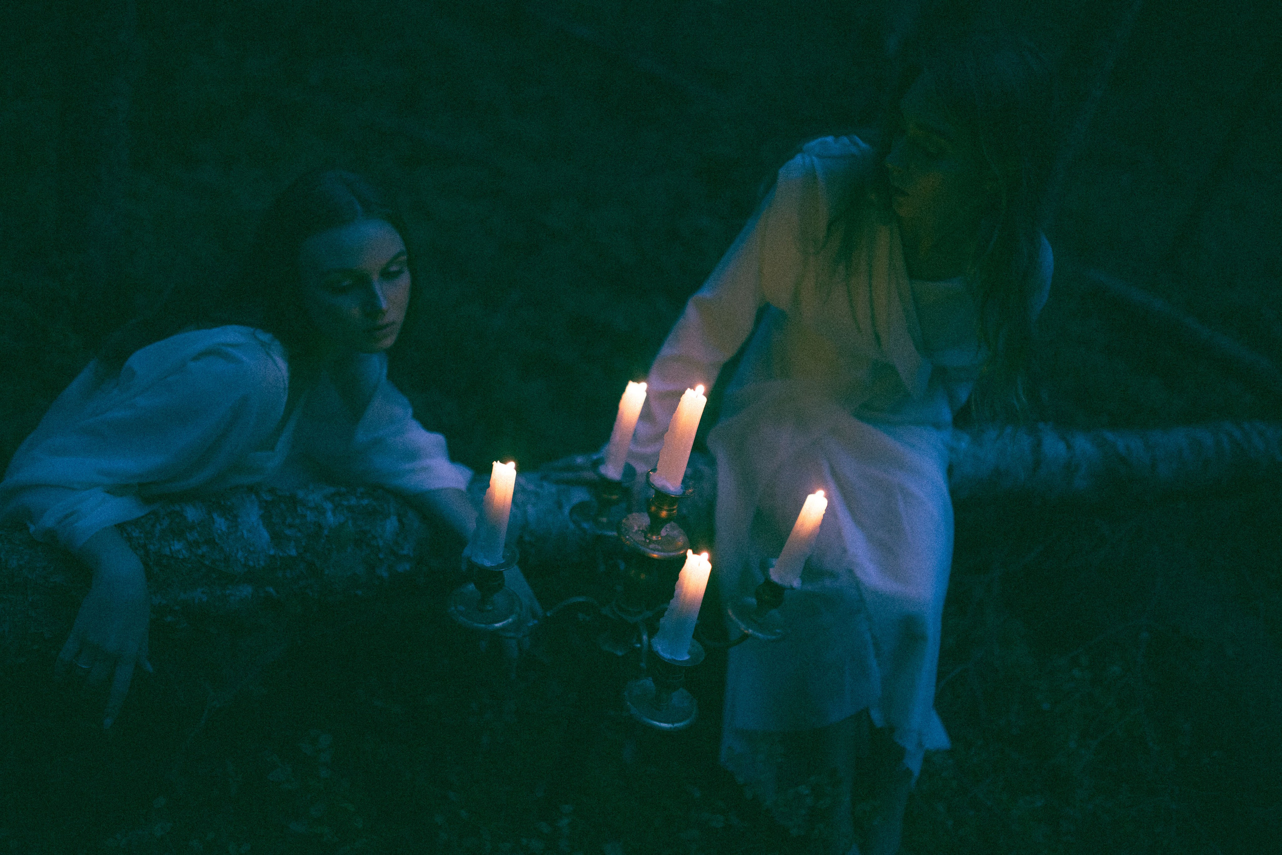 Две девушки смотрят на горящие свечи