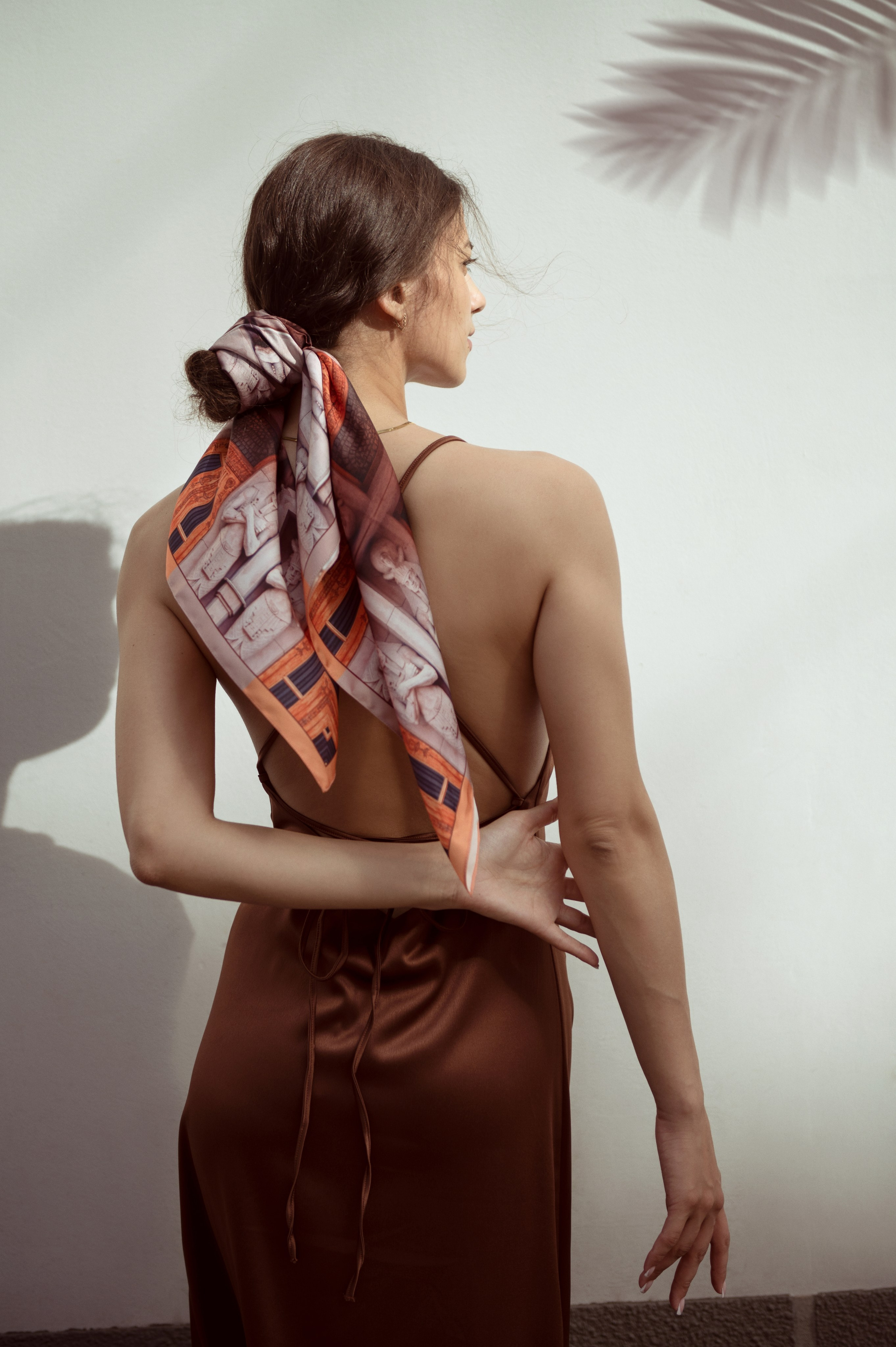 красивая девушка в терракотовом платье-комбинации и шелковым платком на низком пучке