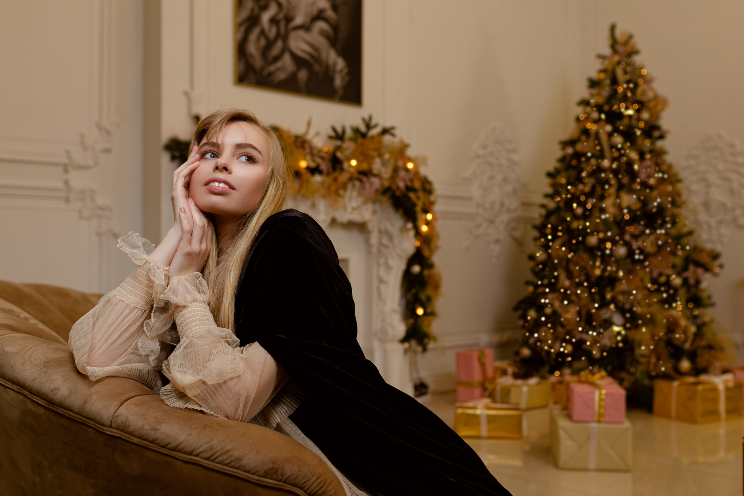 Девушка держит руки улица и смотрит в потолок в студии где есть ёлка