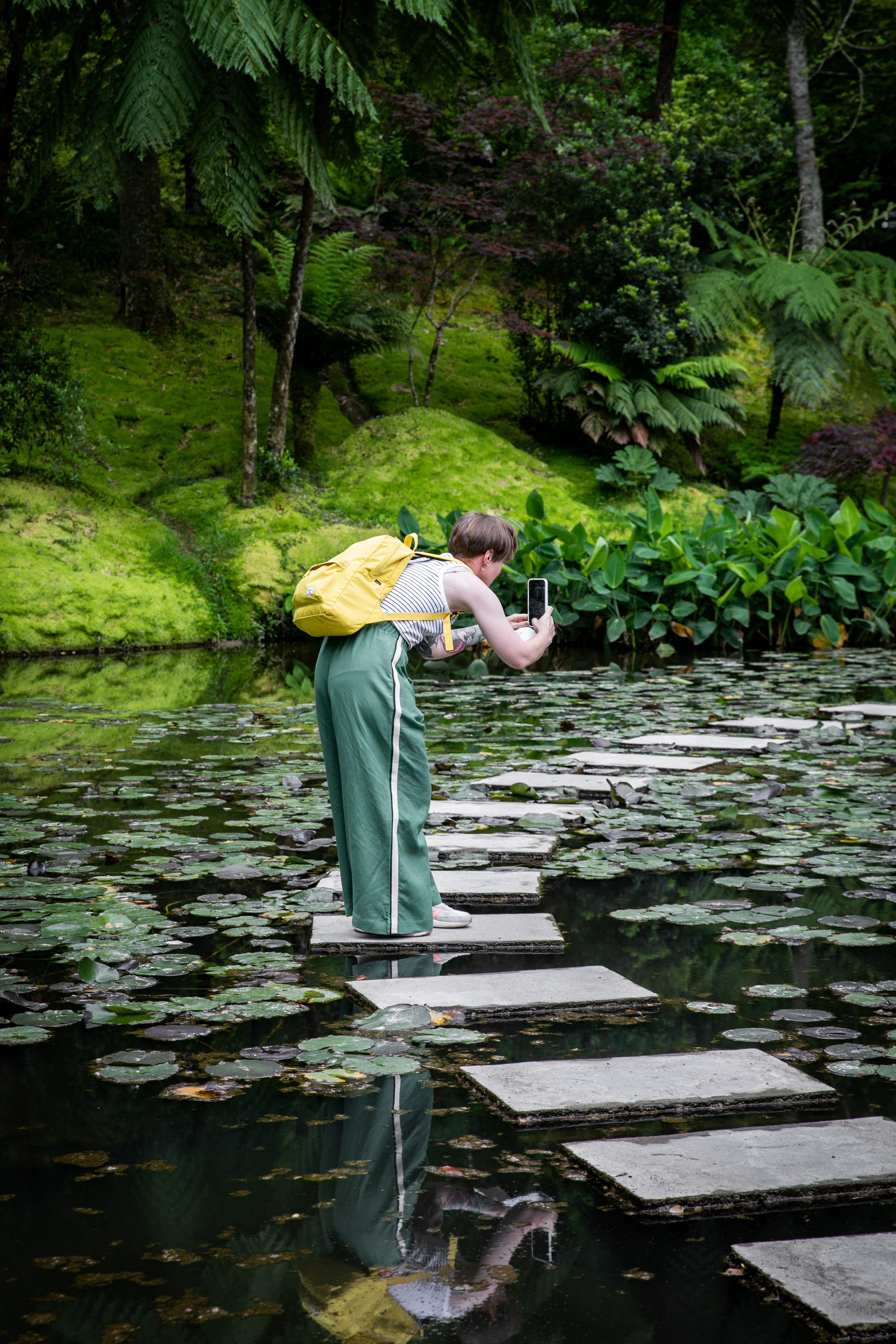 Women wander through the stunning landscapes of the Azores, surrounded by green hills, the ocean, and an open sky above
