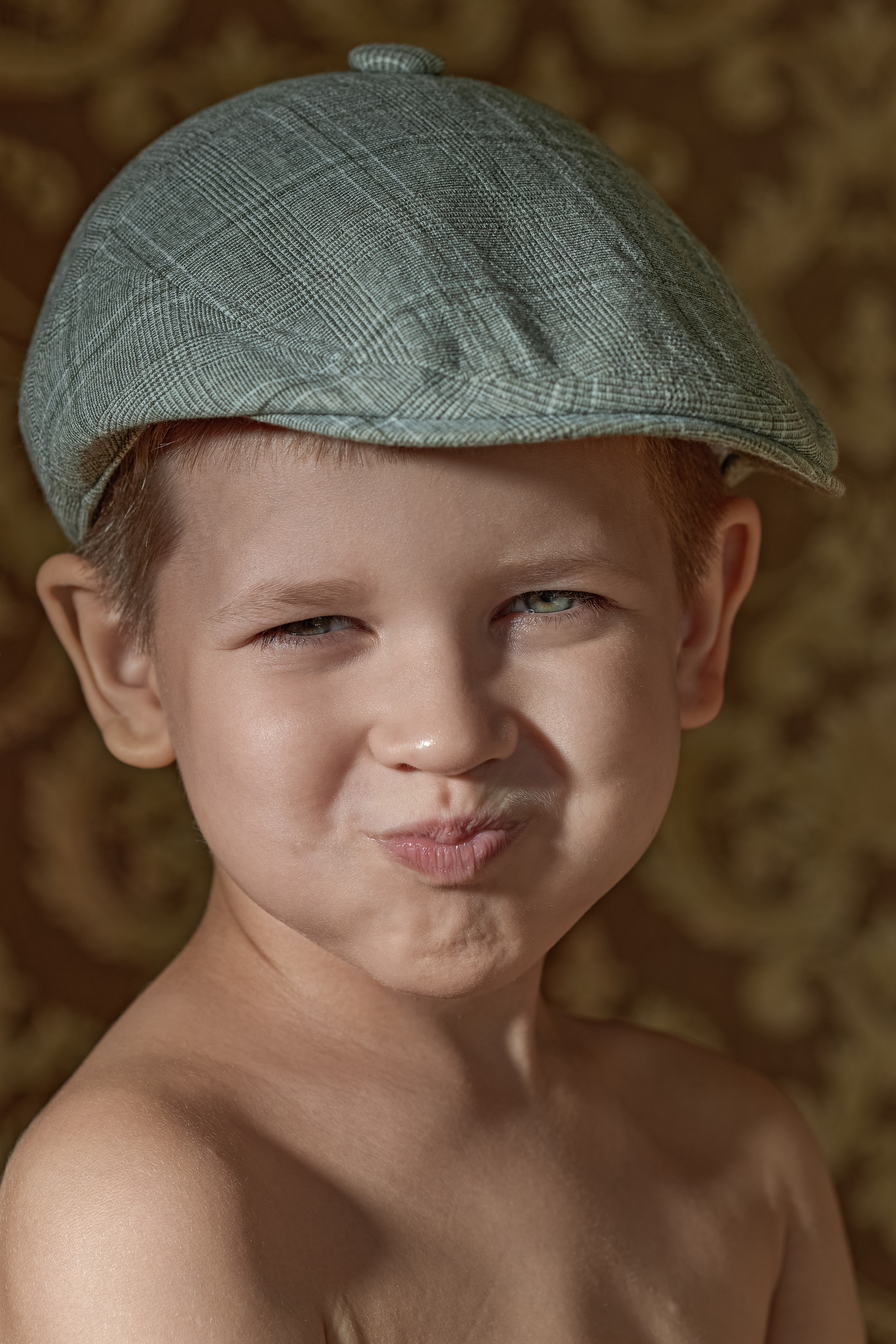 Детский портрет, мальчик угорает со смеху, он в кепке