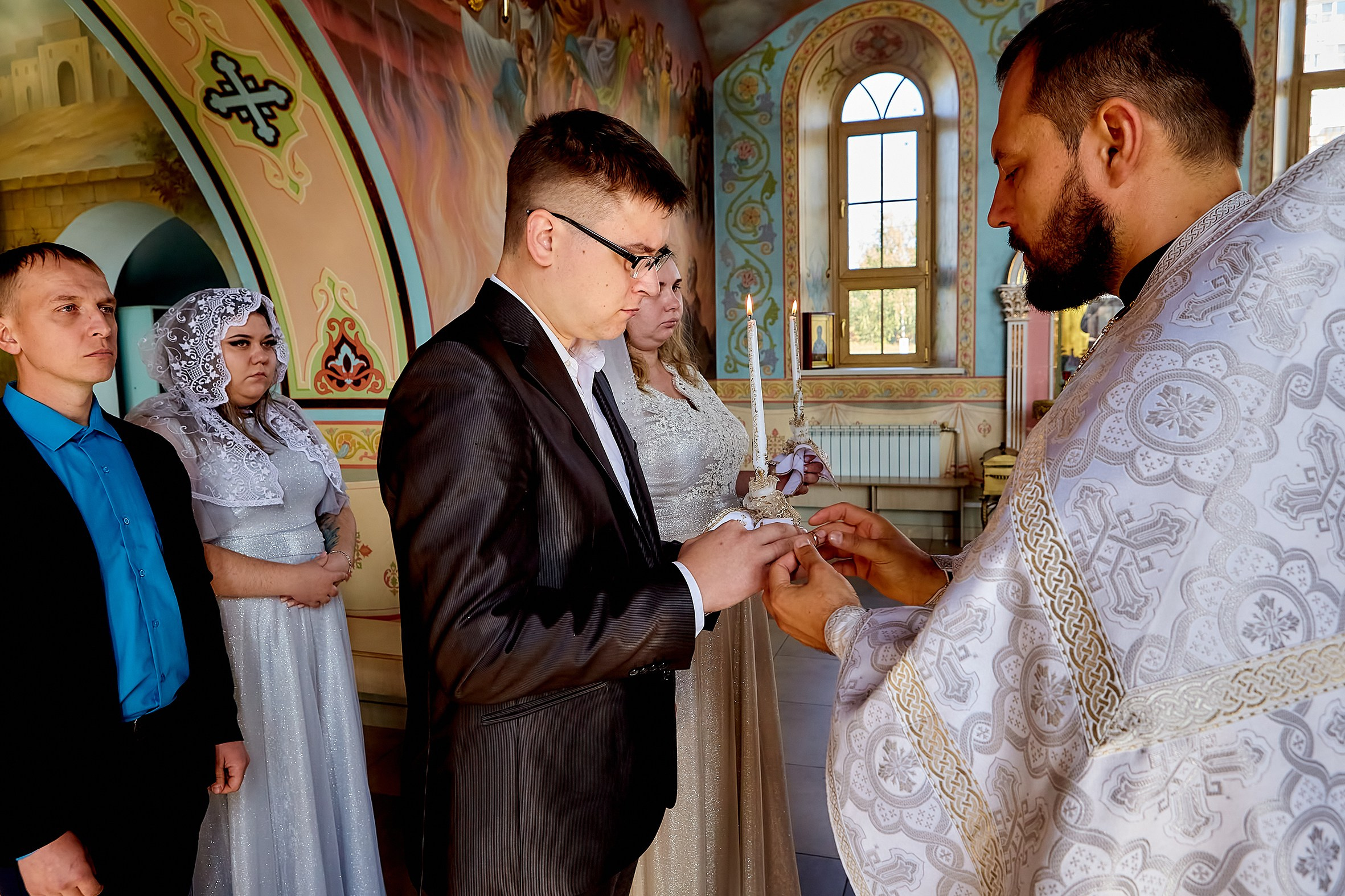 Священник производит по таинству обмен кольцами жениха и невесты