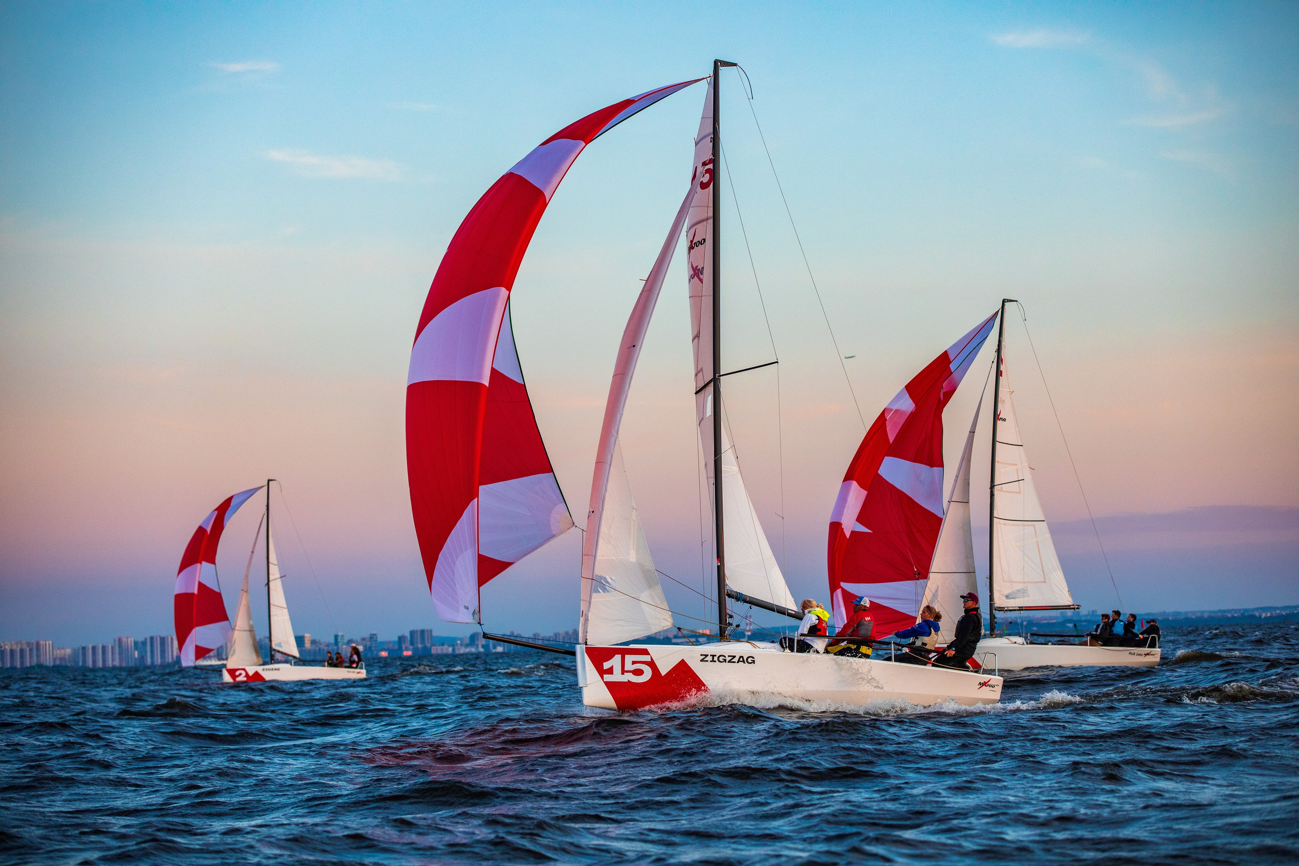 Три парусных яхты на закате. Красивое, живописное небо.