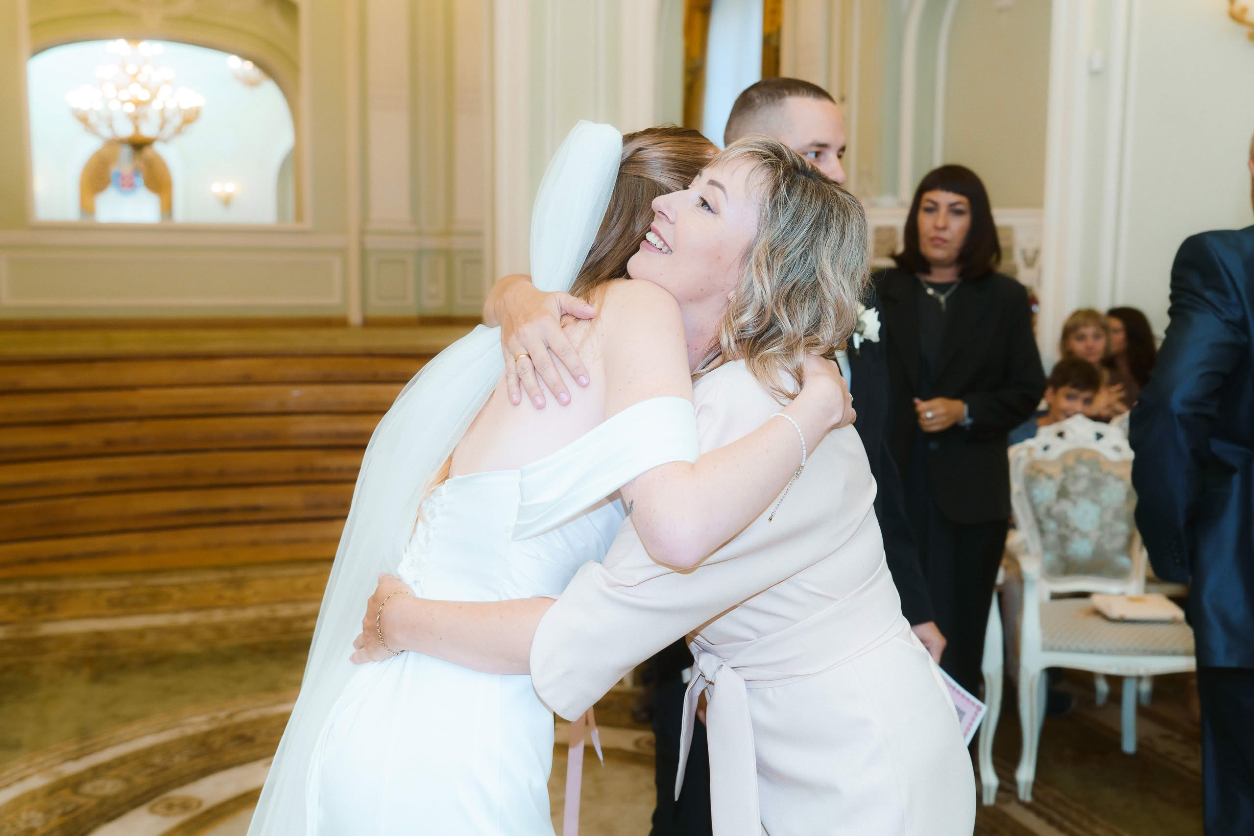 Объятия невесты с мамой после регистрации брака