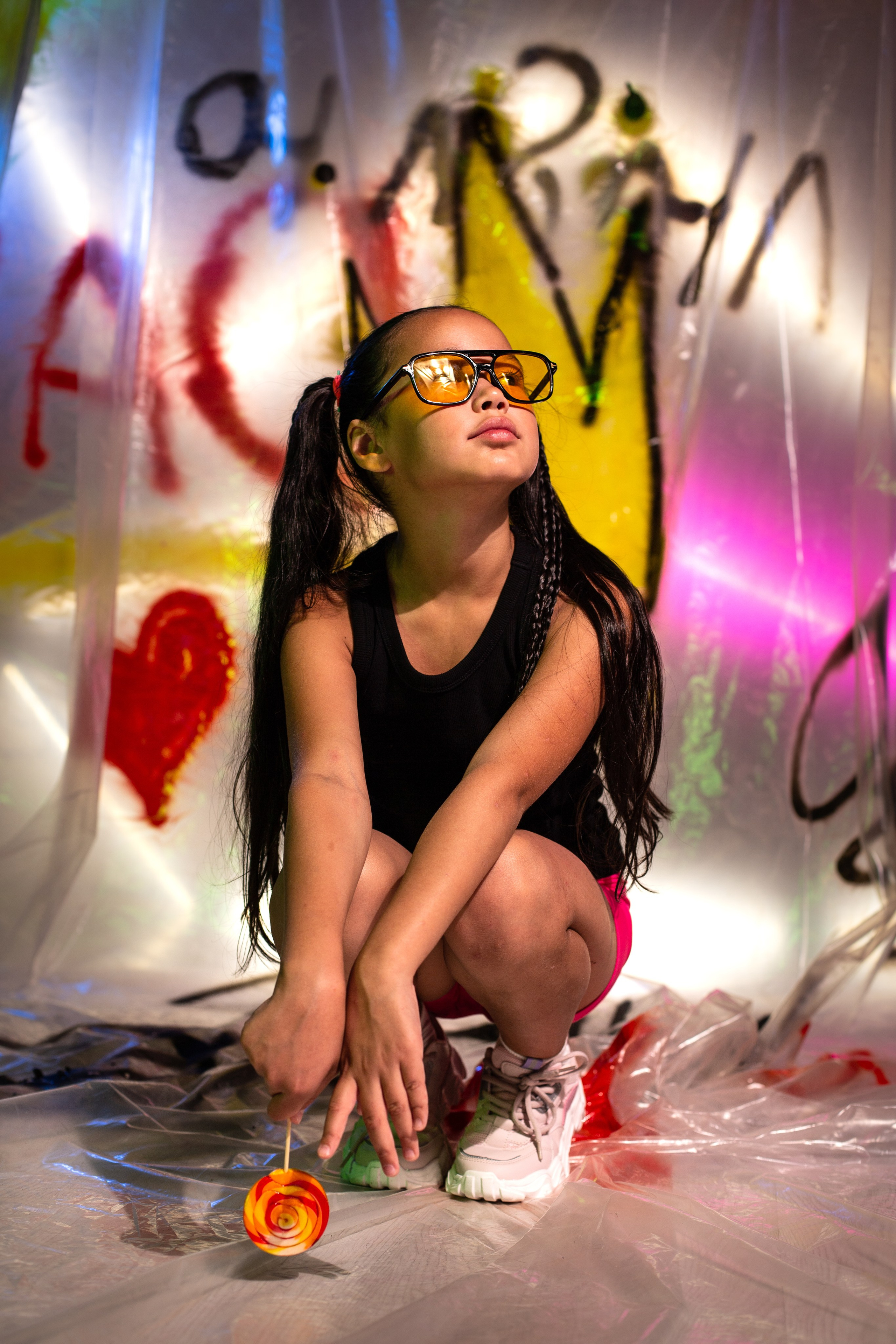 девочка в желтых очках и с разноцветным леденцом на фотосессии