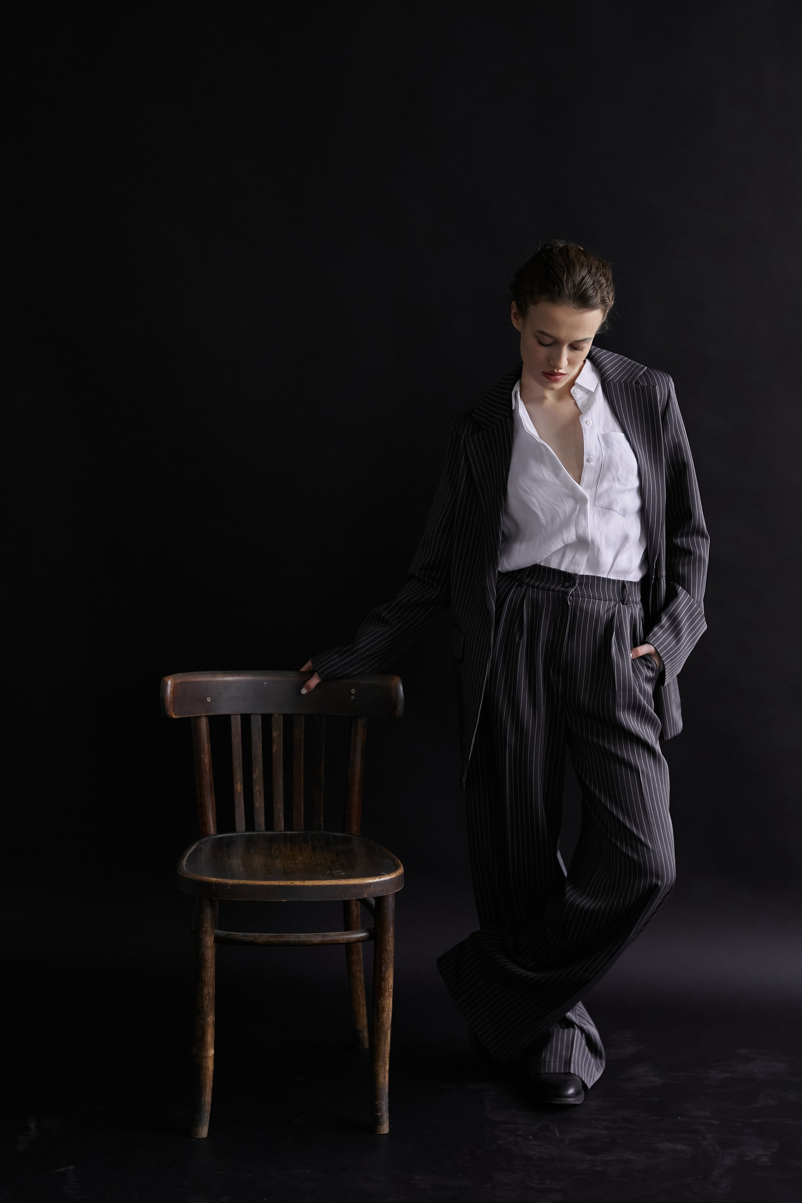 Фотограф в Москве. Студия. Студийный портрет. Девушка в пиджаке. Девушка на стуле на черном фоне. Красивая девушка в мужском костюме. Женский портрет.