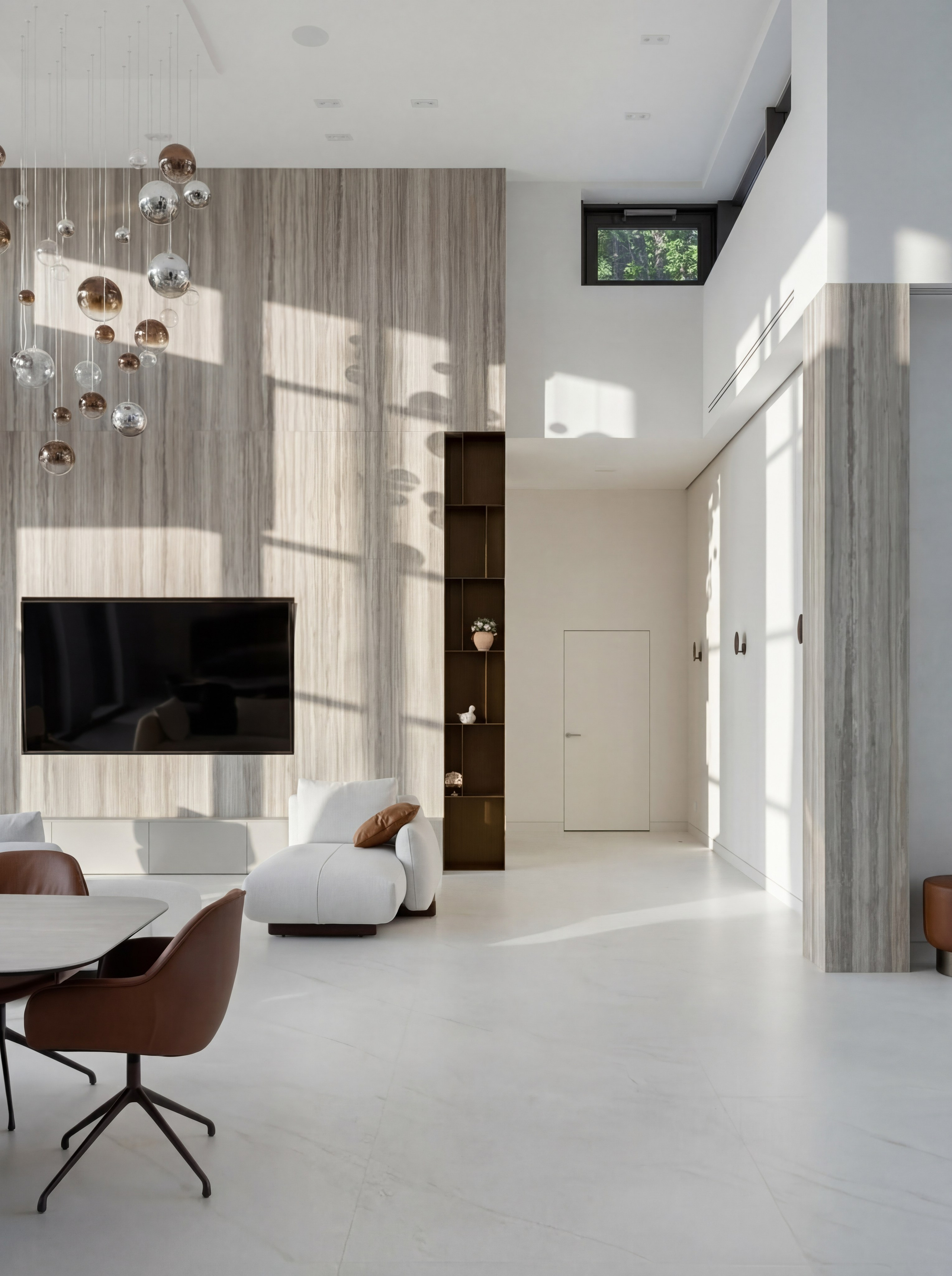 Минималистичный дизайн холла и ТВ-зоны от Валерии Котович: высокие стены с отделкой под травертин, скрытая дверь, каскадная люстра со стеклянными сферами и современная мебель в двухсветном пространстве дома у воды.