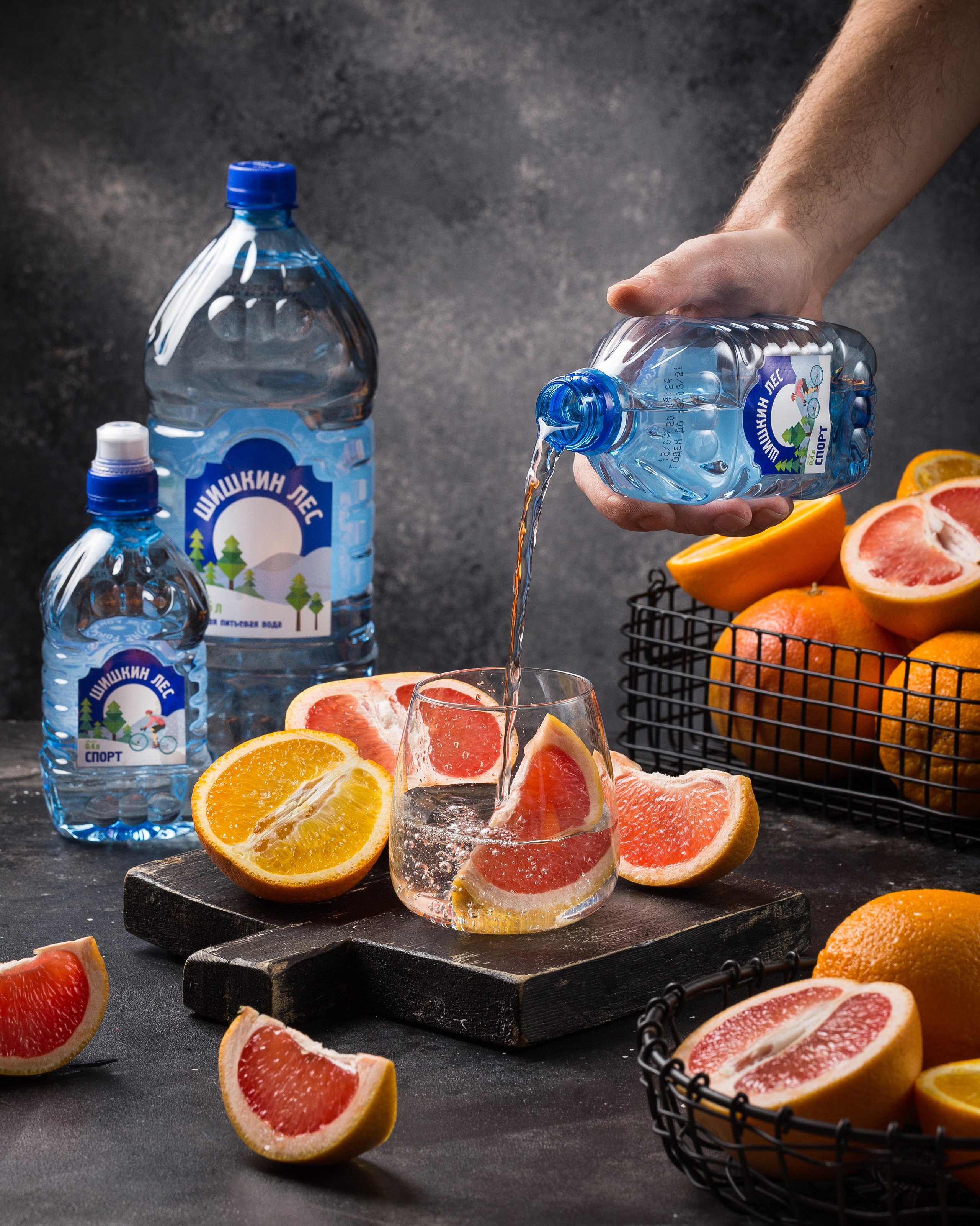 Вода красиво наливается в бокал с грейпфрутом.