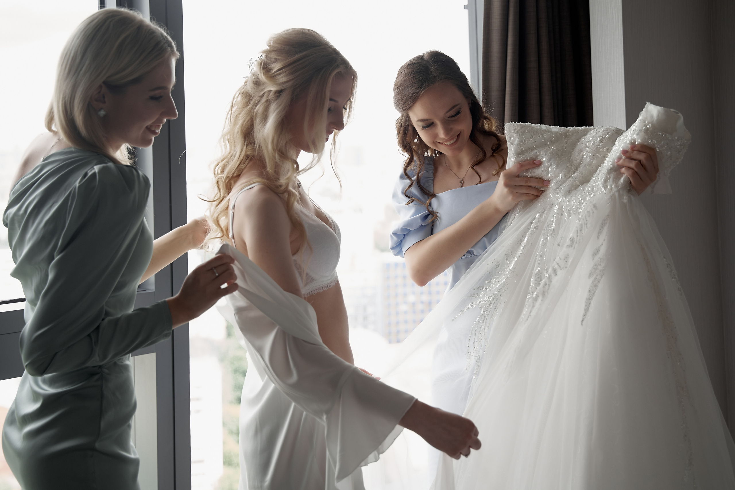 подруги помогают невесте одеть свадебное платье Свадебная фотосъемка в Москве. Свадебный фотограф в Москве  Сергей Гаварос.