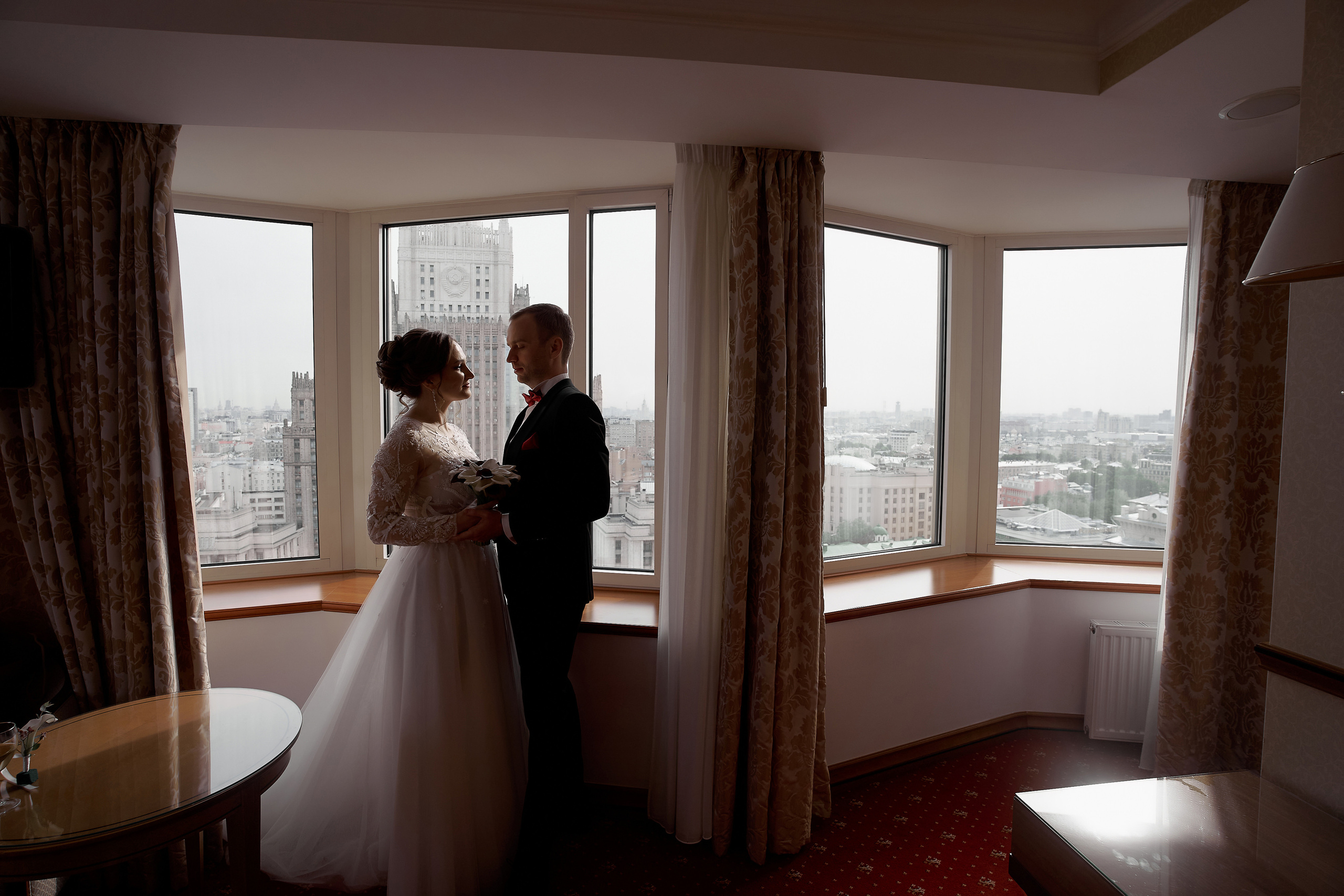 Молодожены обнявшись стоят у окна Свадебная фотосъемка в Москве. Свадебный фотограф в Москве Сергей Гаварос. — Круто снимаю любые свадьбы! — Помогу с позированием и подбором локаций Доступные цены.