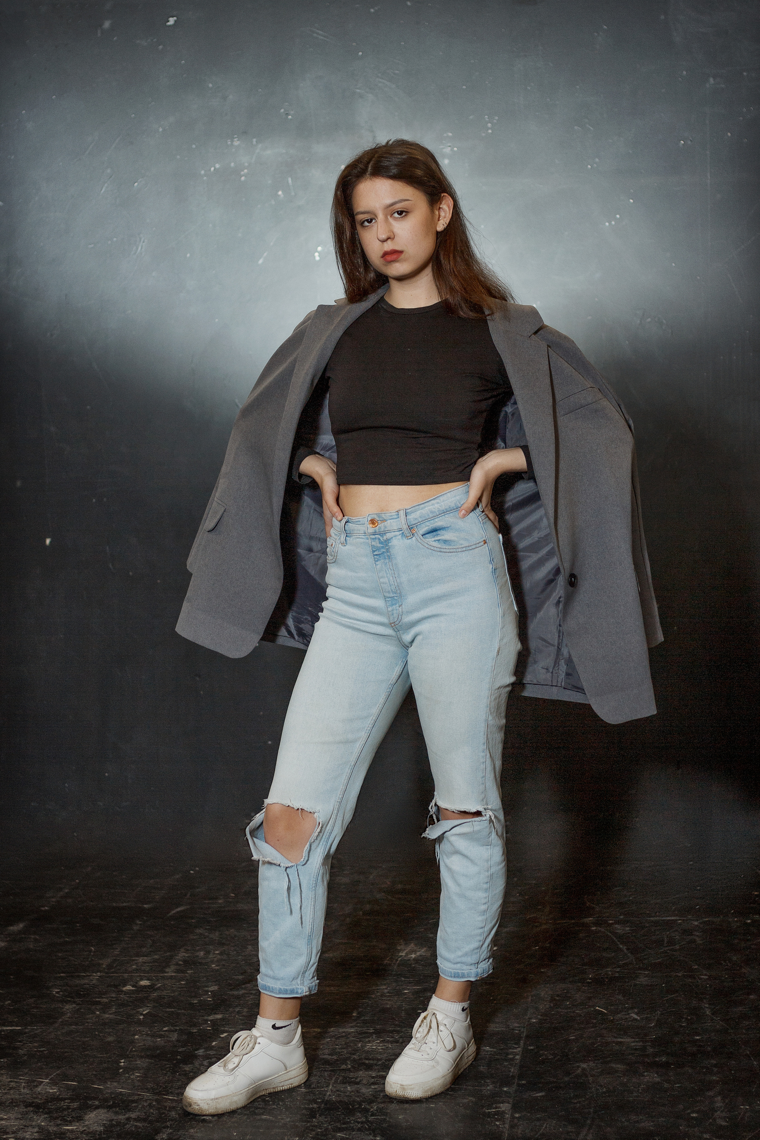 Девушка стоит, накинув на плечи пиджак