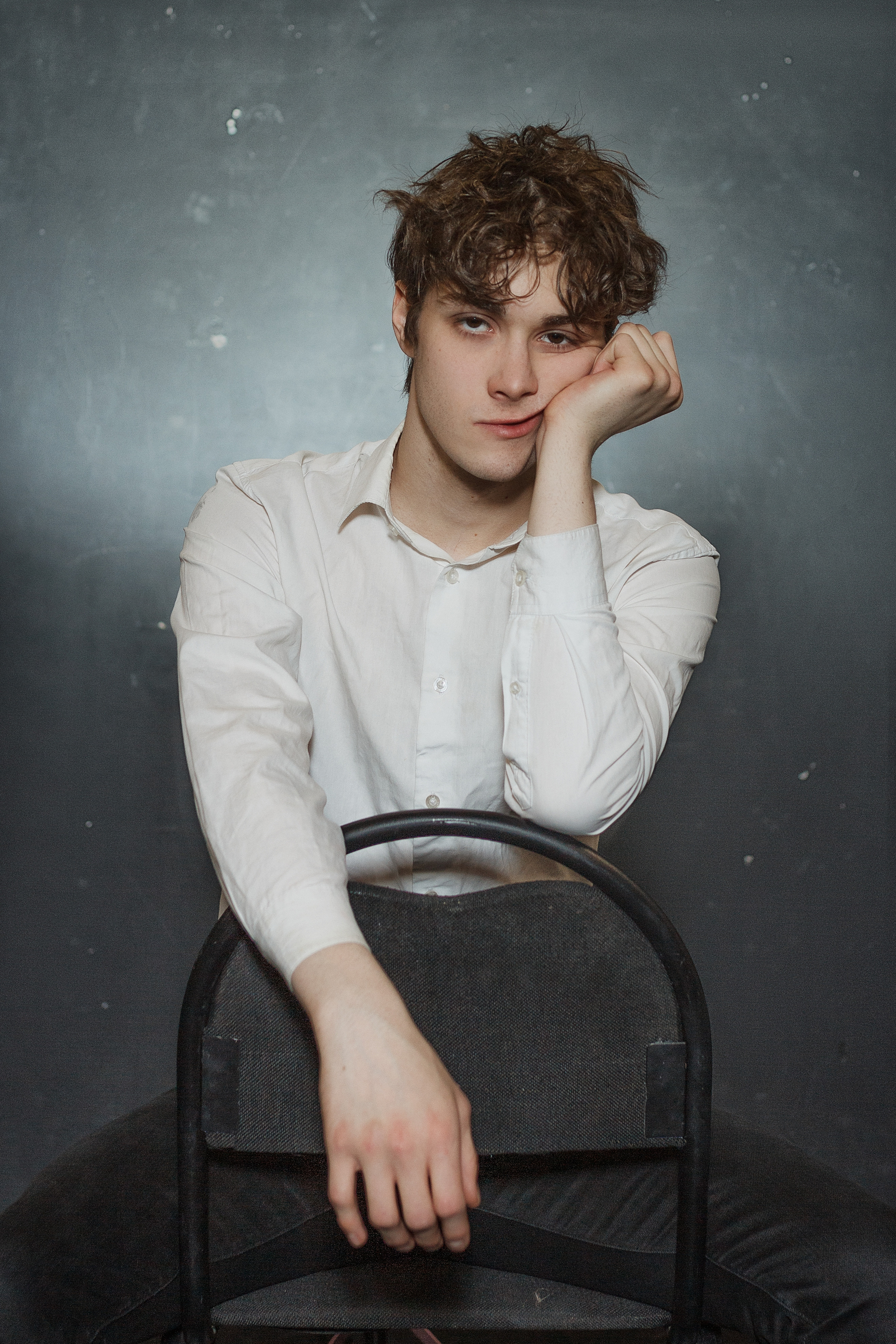 Молодой человек скучающе смотрит в кадр