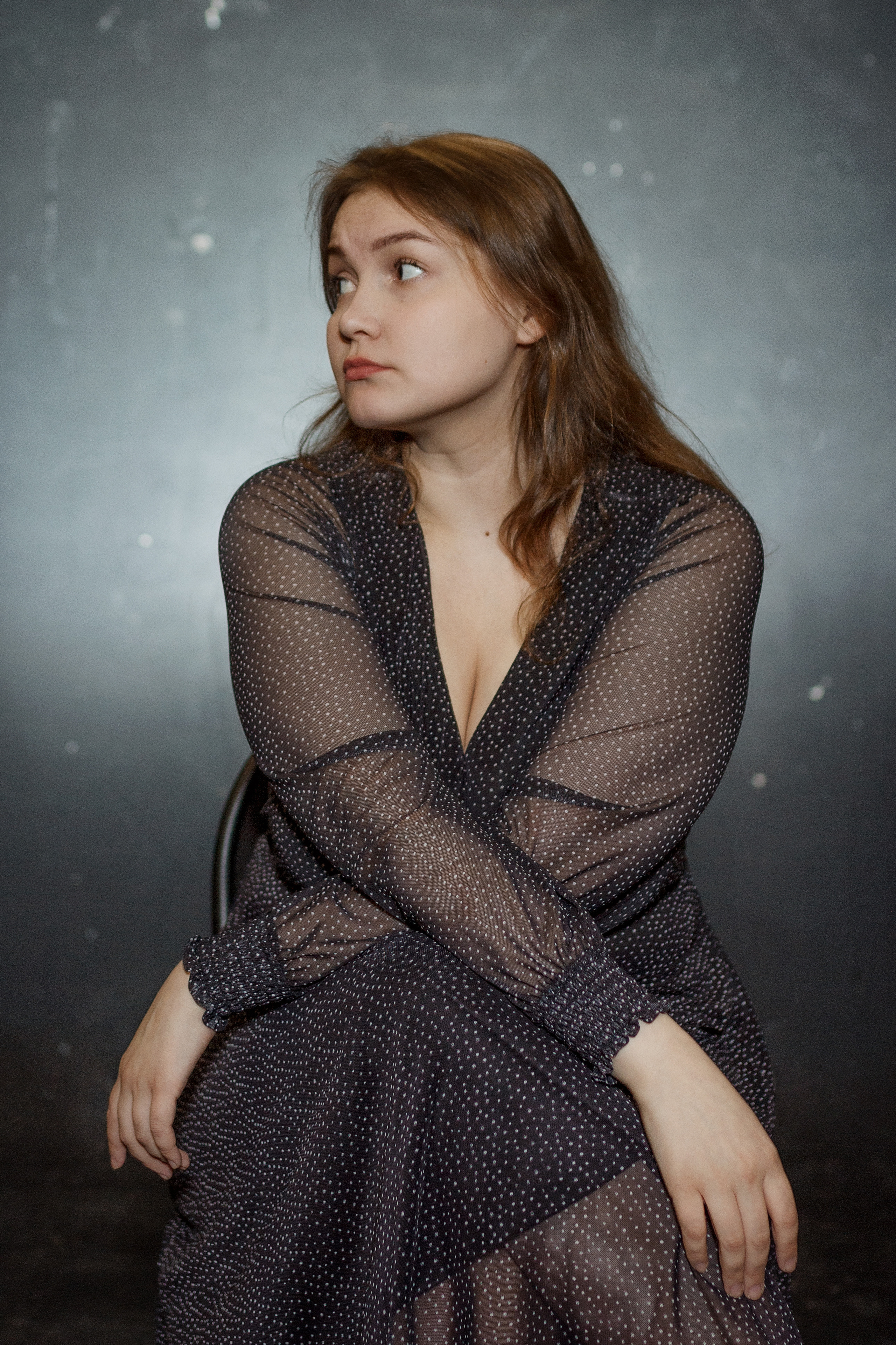 Портрет сидящей на стуле девушки