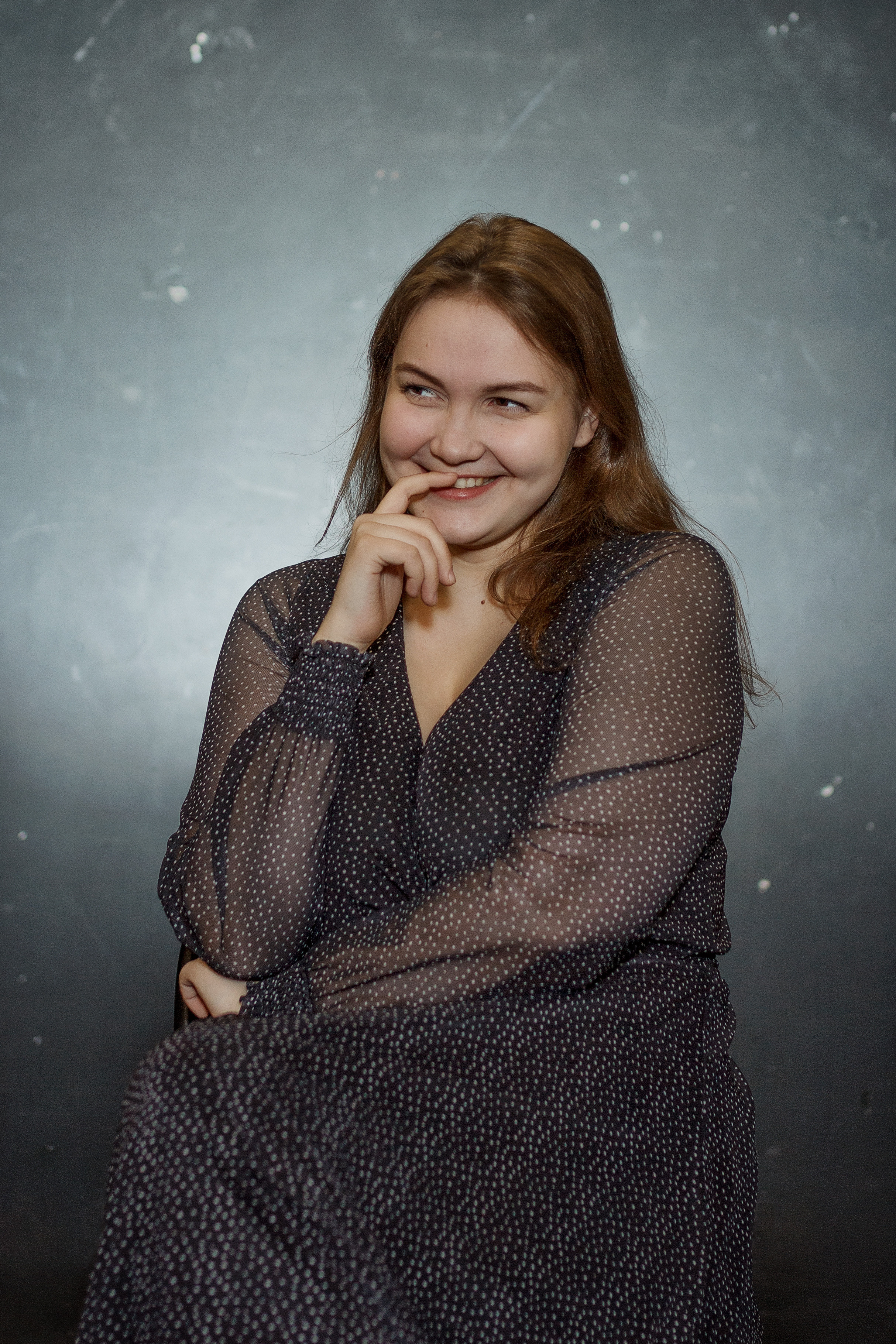 Девушка в платье с распущенными волосами улыбается