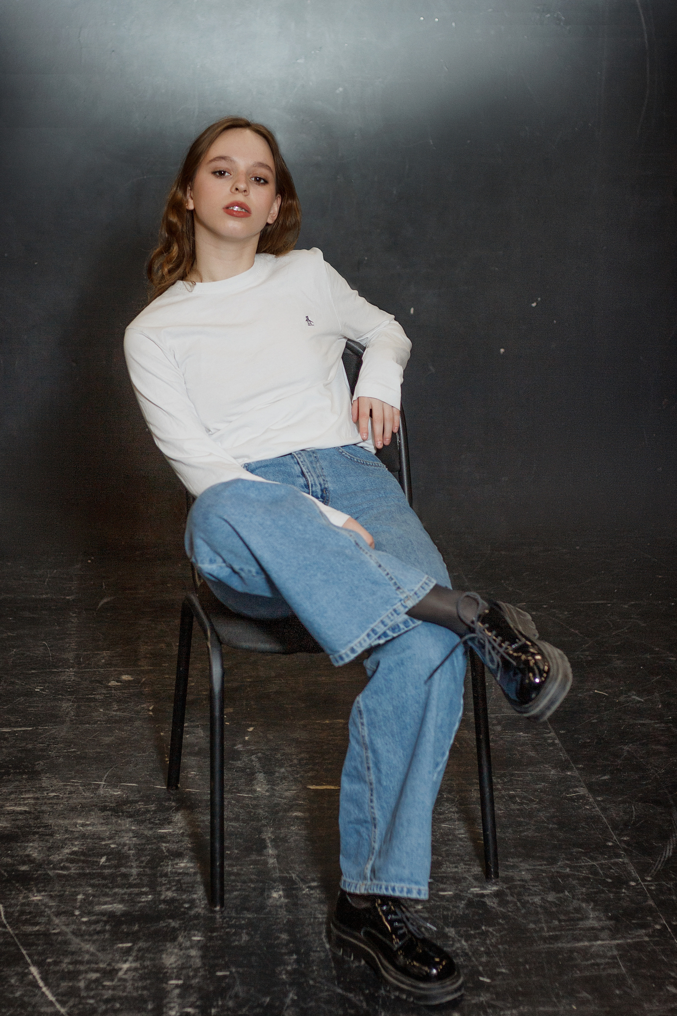 Девушка в джинсах позирует сидя