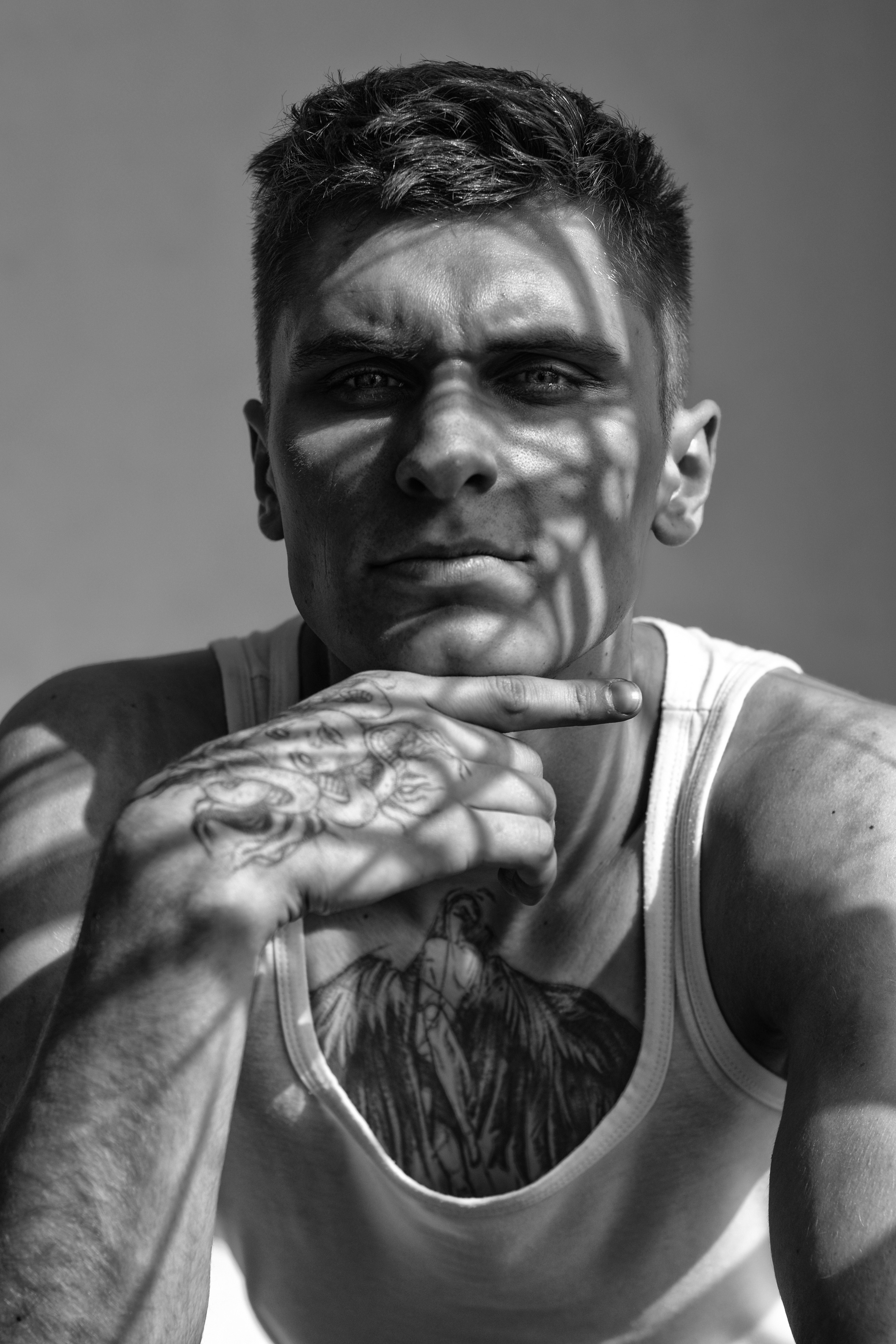 крупный мужской портрет черно-белый, мужчина в майке напротив окна 