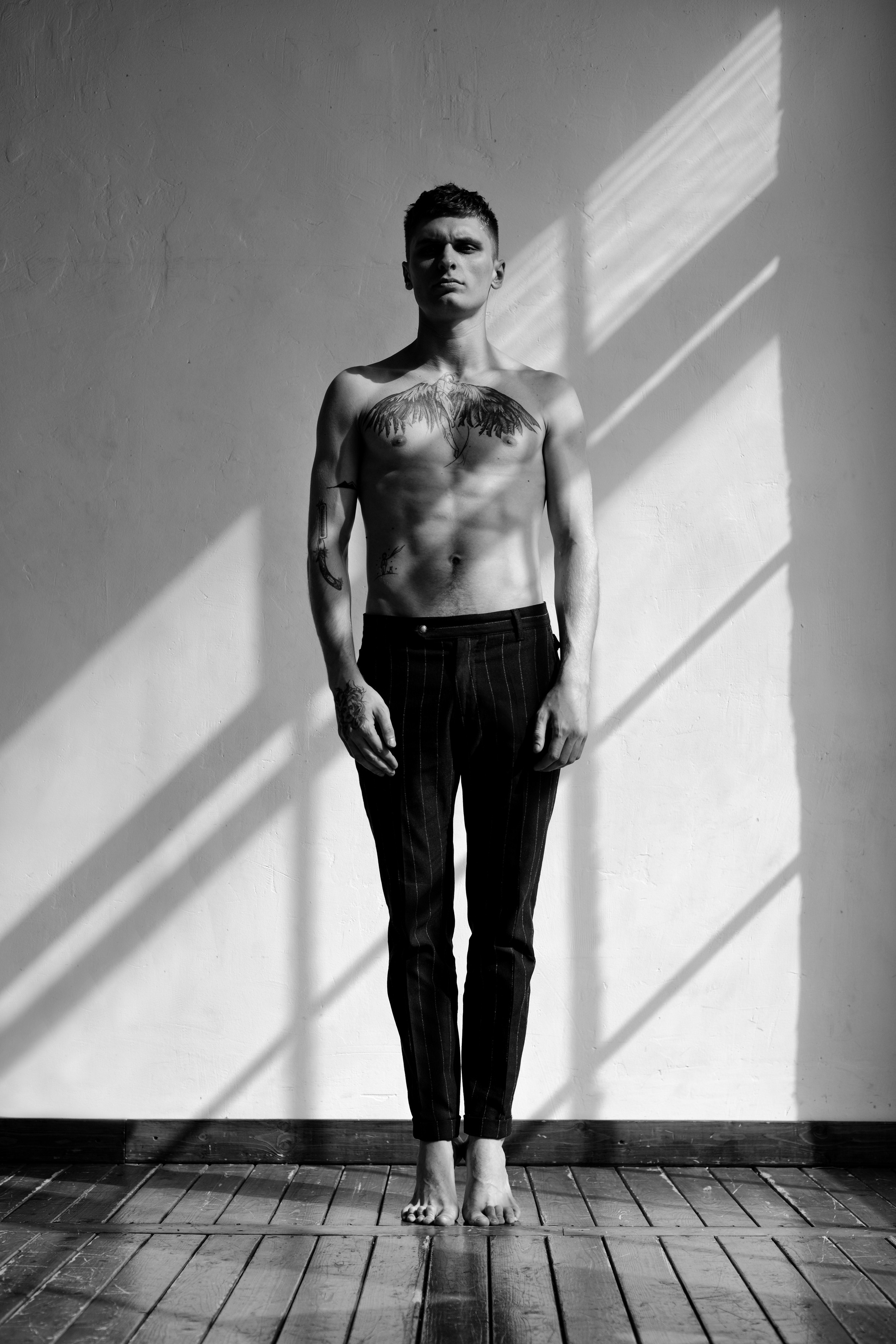 мужской портрет черно-белый, мужчина без майки напротив окна в естественном свете 