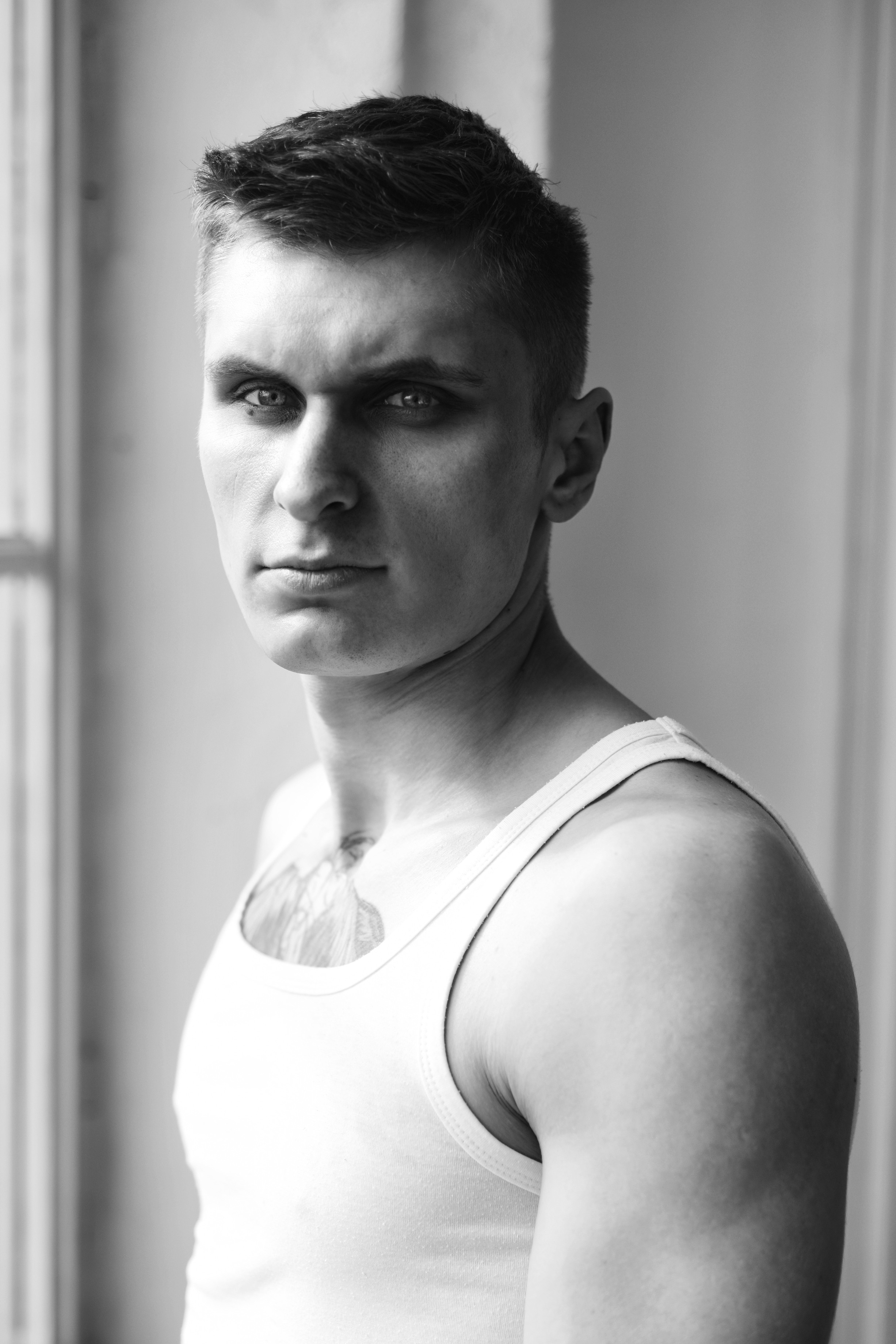 крупный мужской портрет черно-белый, мужчина в майке напротив окна 